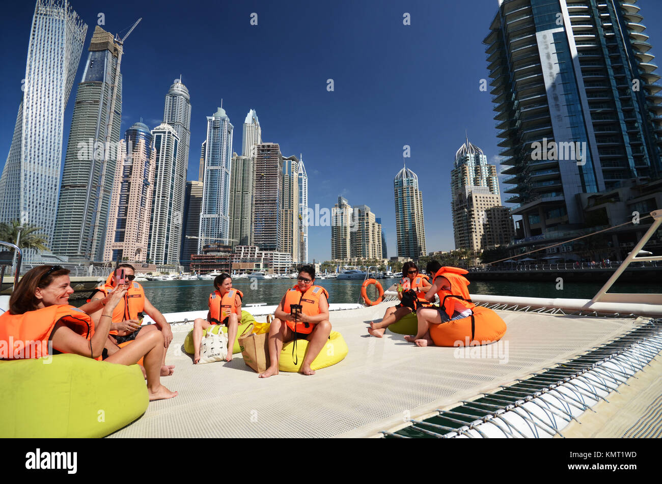 Menschen auf Katamaran in Dubai suchen in Richtung City Skyline und Sky Scraper Stockfoto