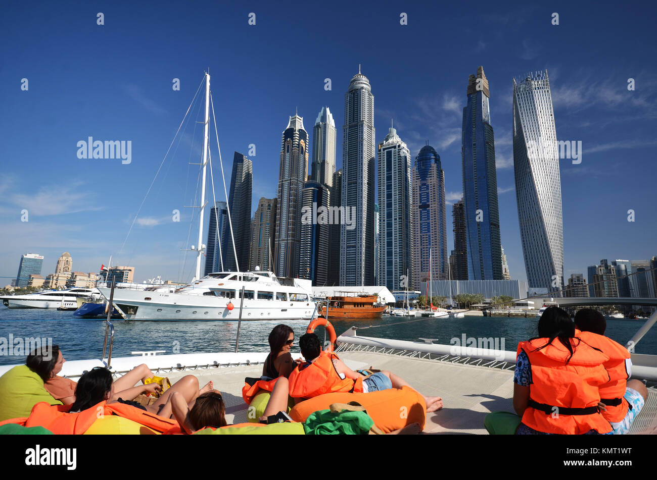 Menschen auf Katamaran in Dubai suchen in Richtung City Skyline und Sky Scraper Stockfoto