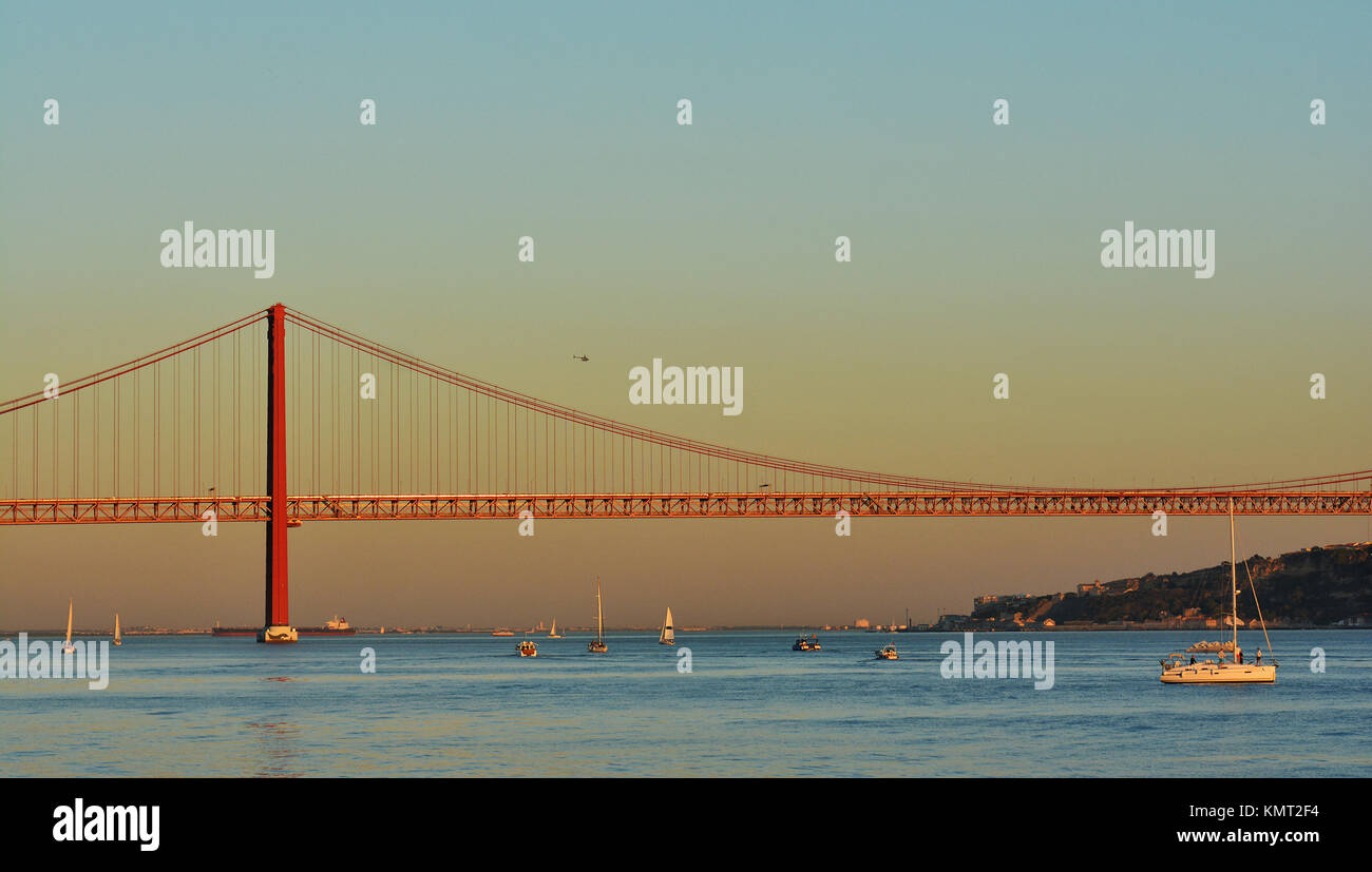 Sonnenuntergang über den Tagus Fluss mit Brücke "25 de Abril" in Lissabon, Portugal Stockfoto