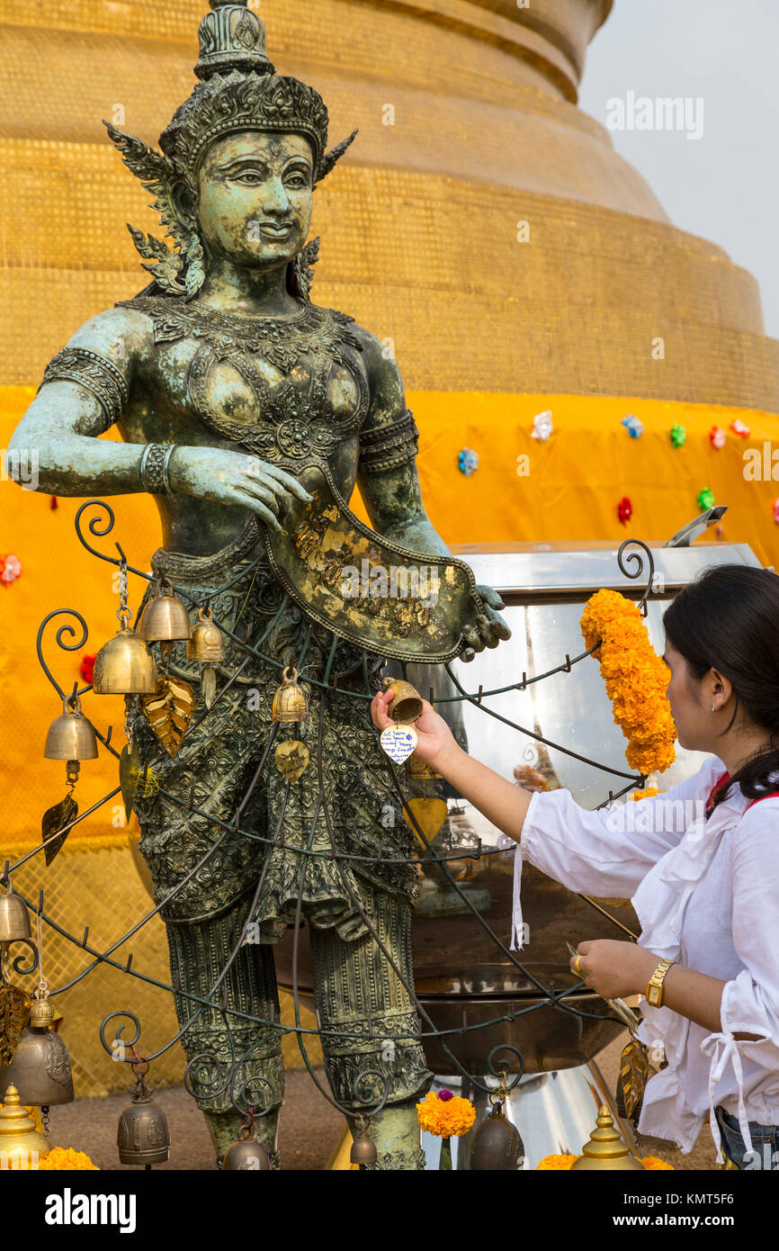 Bangkok, Thailand. Frau hängt Glocke durch den Gott der Bereich der Wat Saket (Phu Khao Thong), Der goldene Berg, Wache an der Ecke der goldenen Chedi. Stockfoto