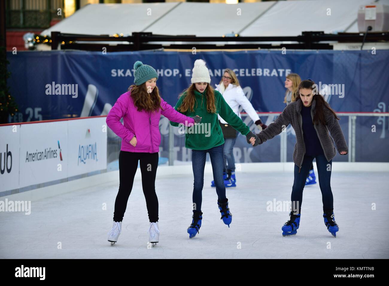Drei Mädchen klammern sich an einander, während sie ihre Weise um die Eisbahn machen während Skating als Chicagos Wrigleyville Nachbarschaft auf einem Weihnachten dauert und h Stockfoto