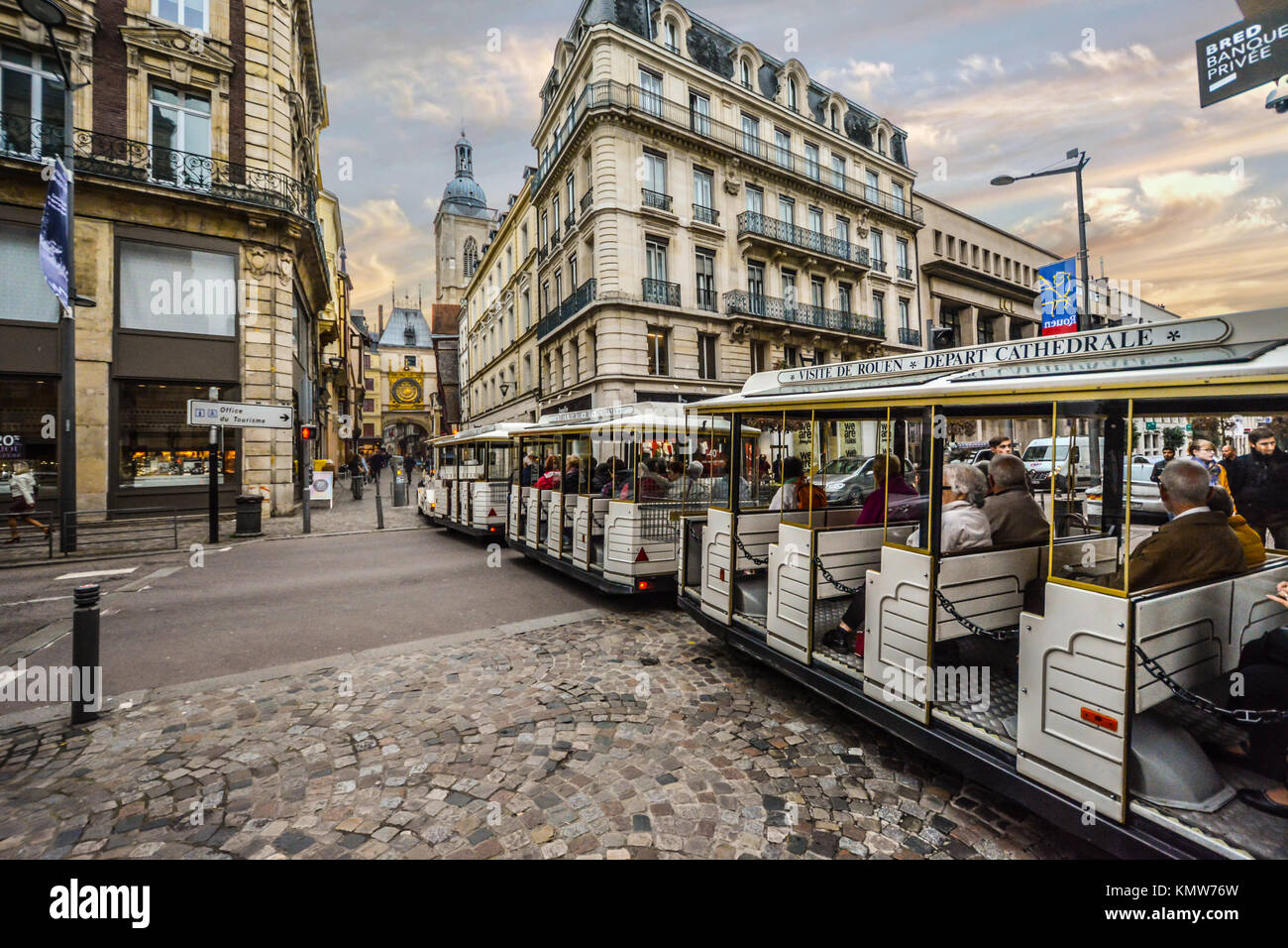 Touristen fahren mit dem Tram Bus mit dem Gros Horloge oder astronomische Uhr in der Ferne in der Normandie Stadt Rouen Frankreich Stockfoto