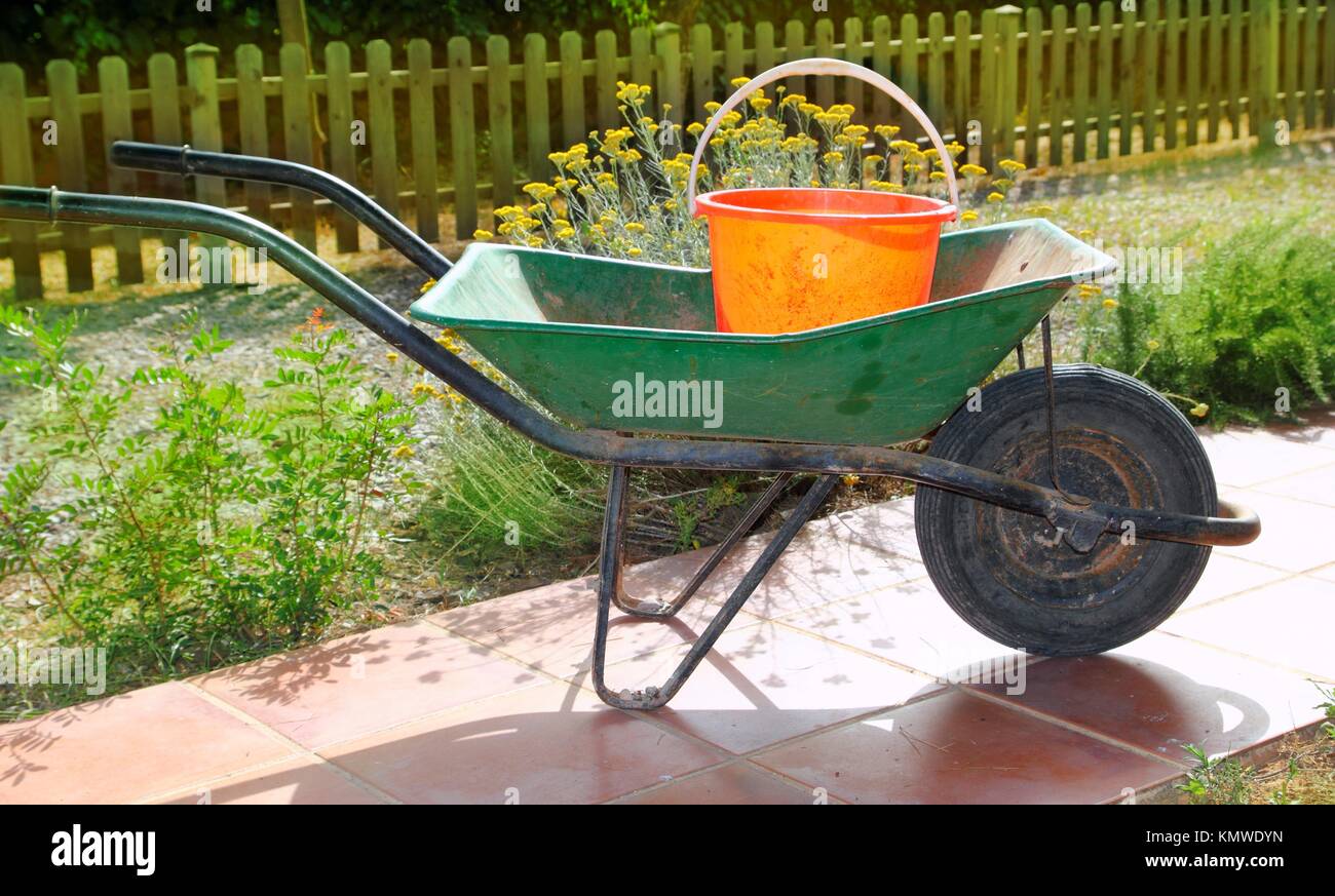 Gärtner grüne Schubkarre mit orange Eimer Cube tools Stockfotografie