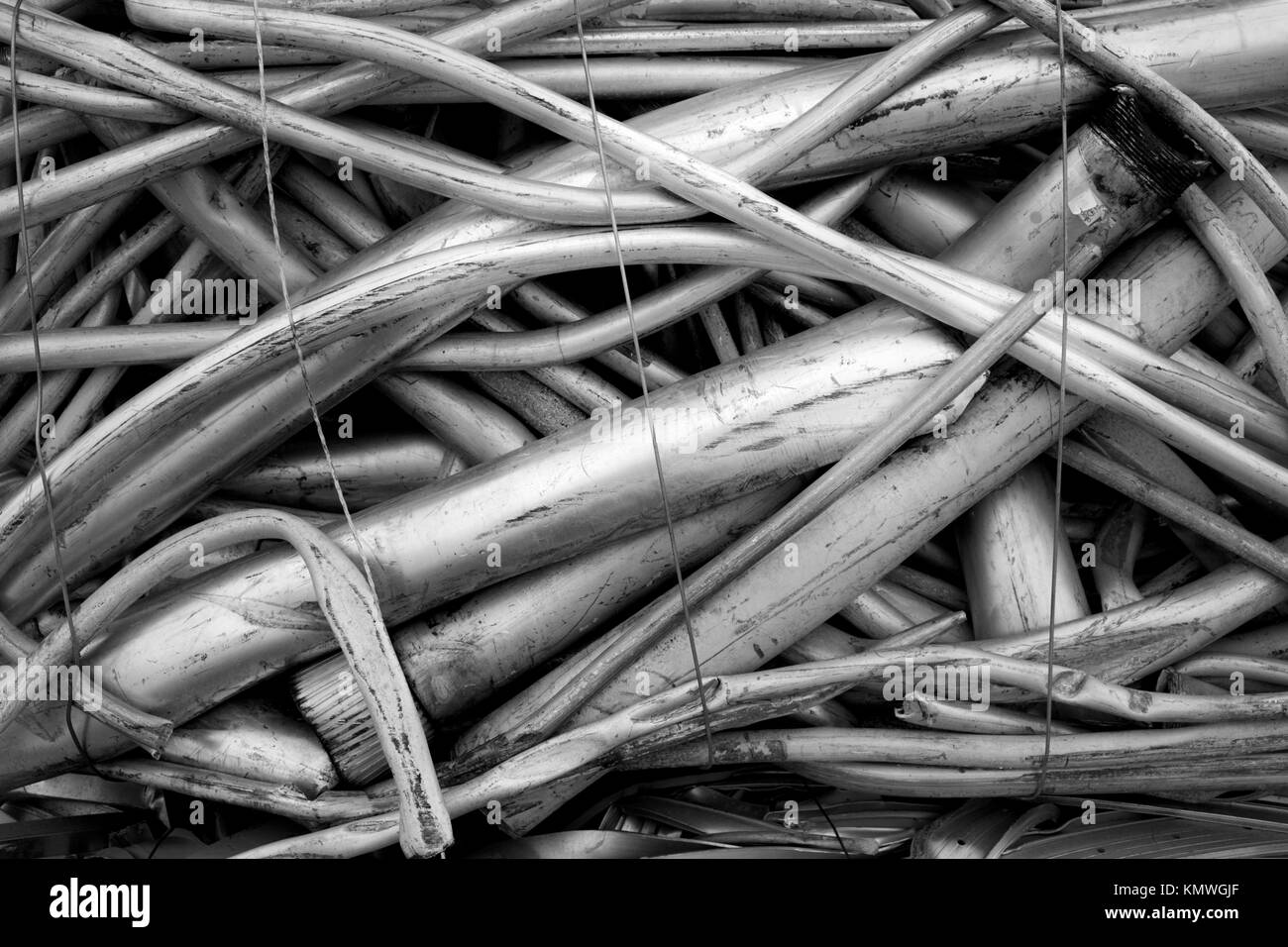 Recycling Center mit Ballen von Metall- und Kran mit Greifer werfen Lkw und rostige Räder Stockfoto