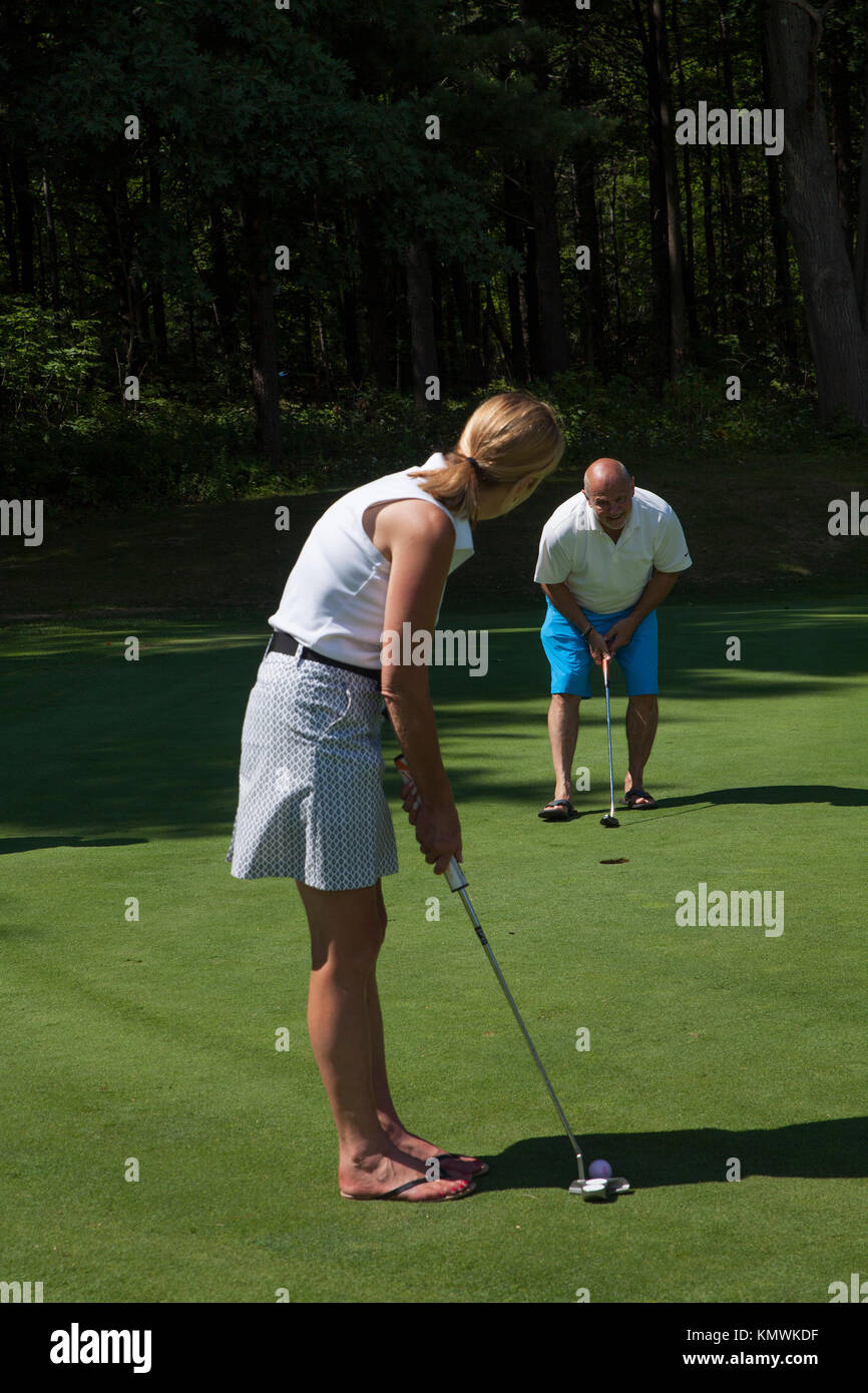 Eine Frau nimmt einen Schuß an einem Golfkurs in Massachusetts, USA. Stockfoto