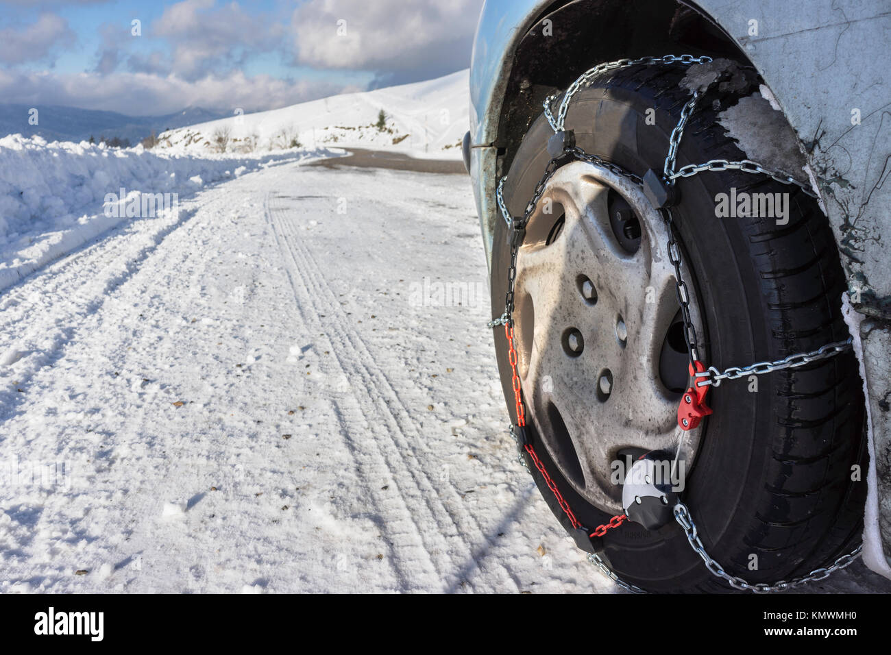 Nahaufnahme von Schneeketten montiert auf einem verschneiten Auto Rad mit großen Kopie Raum auf der linken Seite. Stockfoto