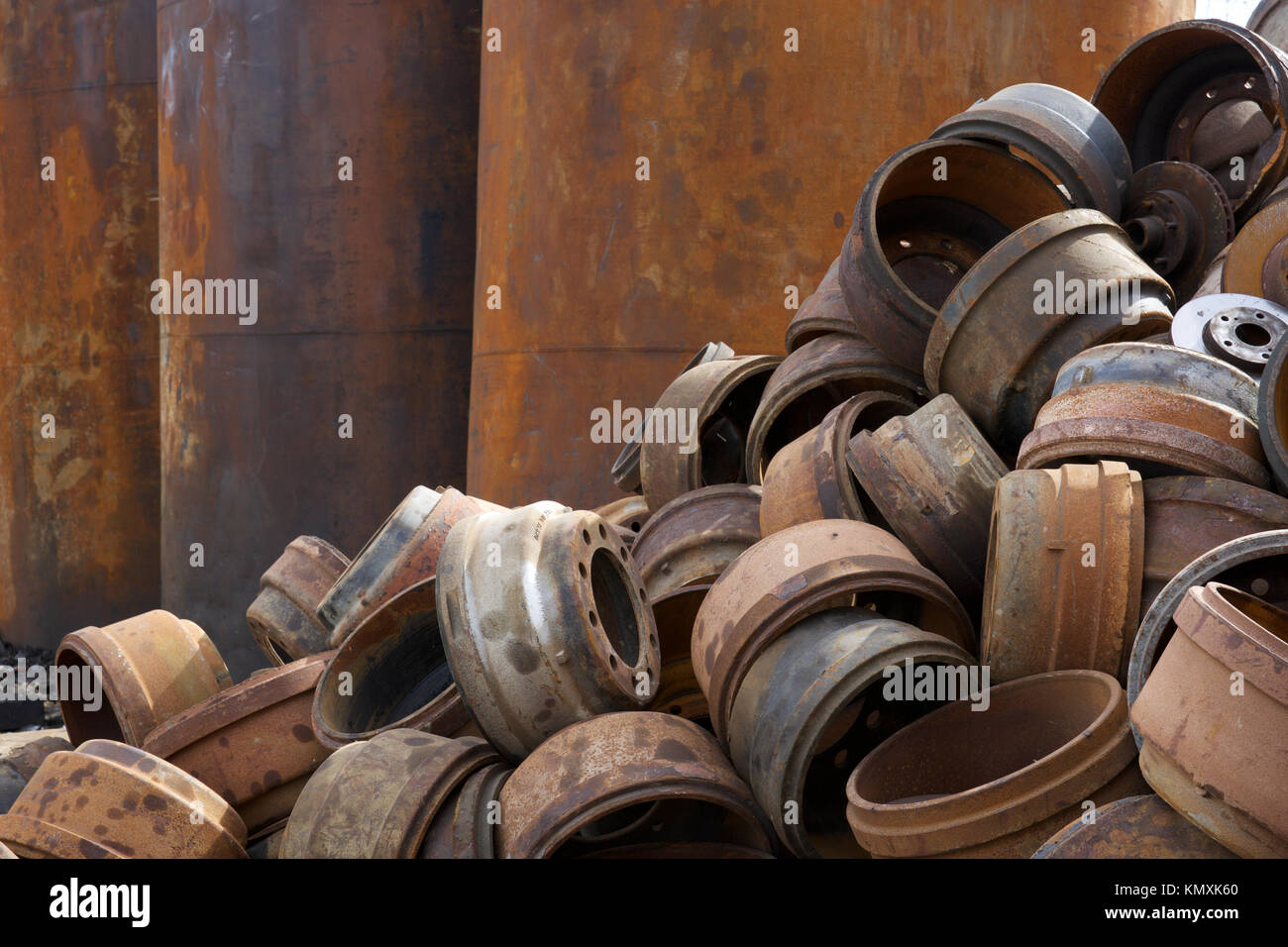 Recycling Center mit Ballen von Metall- und Kran mit Greifer werfen Lkw und rostige Räder Stockfoto