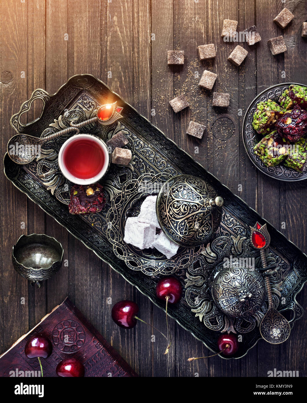 Tee mit türkischen Köstlichkeiten rahat Lokum und Kirsche auf hölzernen Tisch in magischen Farben mit Platz für Ihren Text Stockfoto