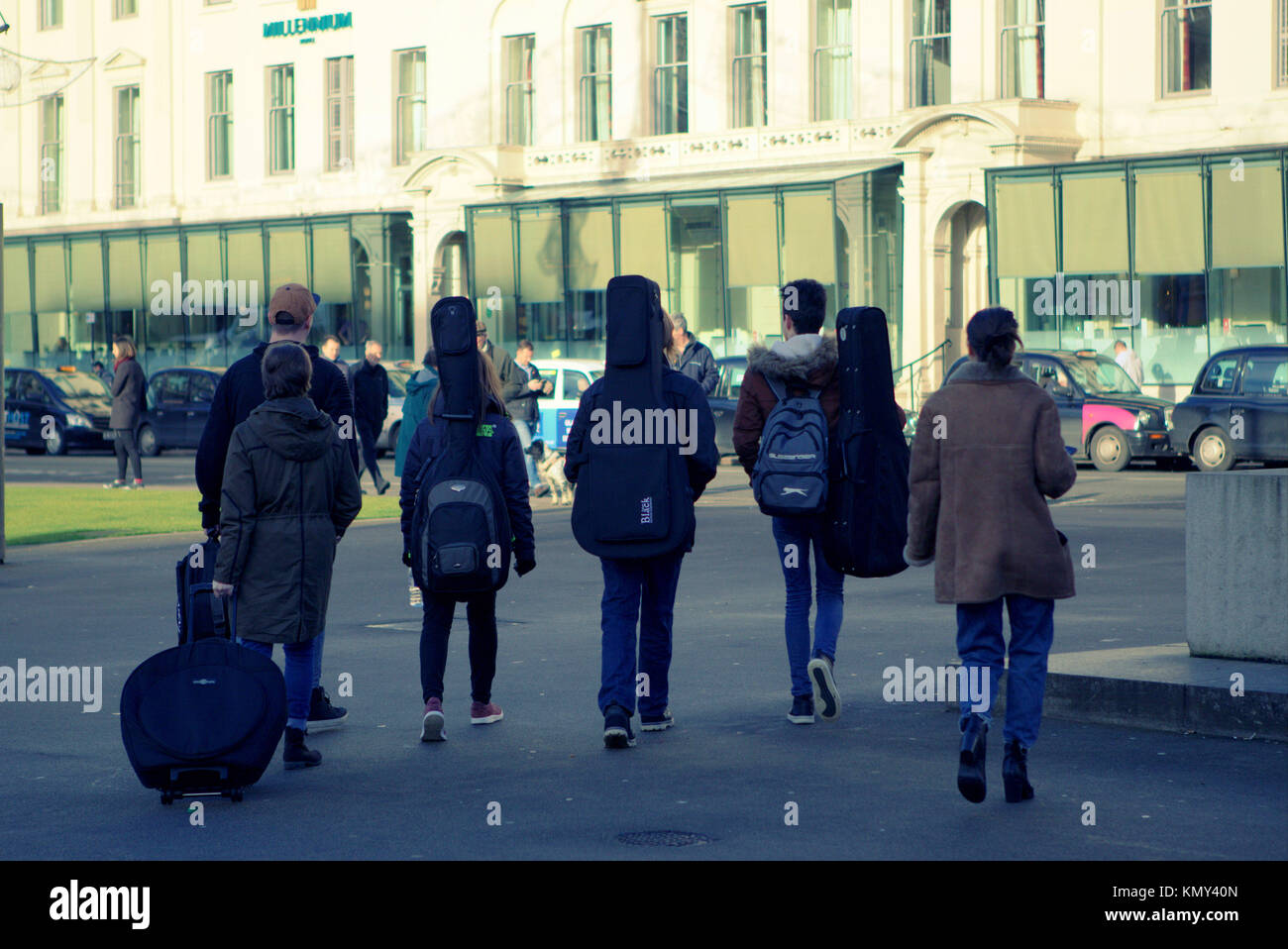 Gruppe band Masse von jungen Menschen zu Fuß auf der Straße Jungen und Mädchen aus gesehen hinter mit Gitarre Fälle, George Square, Glasgow, Vereinigtes Königreich Stockfoto