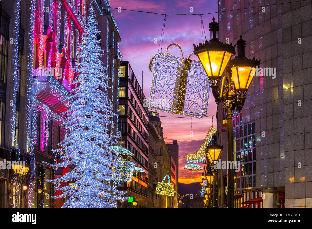 Budapest, Ungarn - schöne Einkaufsstraße Szene mit Lampenhalter, leuchtenden Weihnachtsbaum und Lichtern und Dekorationen und bunten Sonnenuntergang Himmel in Centr Stockfoto