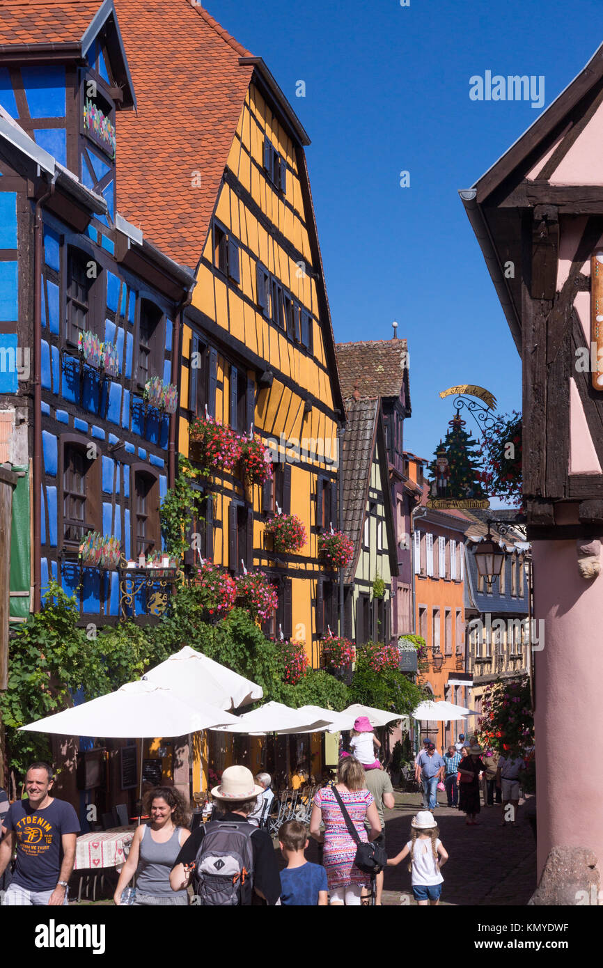 Touristen drängen sich zwischen Maisons à colombages (Fachwerkhäuser) im Elsass, ein beliebtes Reiseziel an der Elsässischen Weinstraße Stockfoto