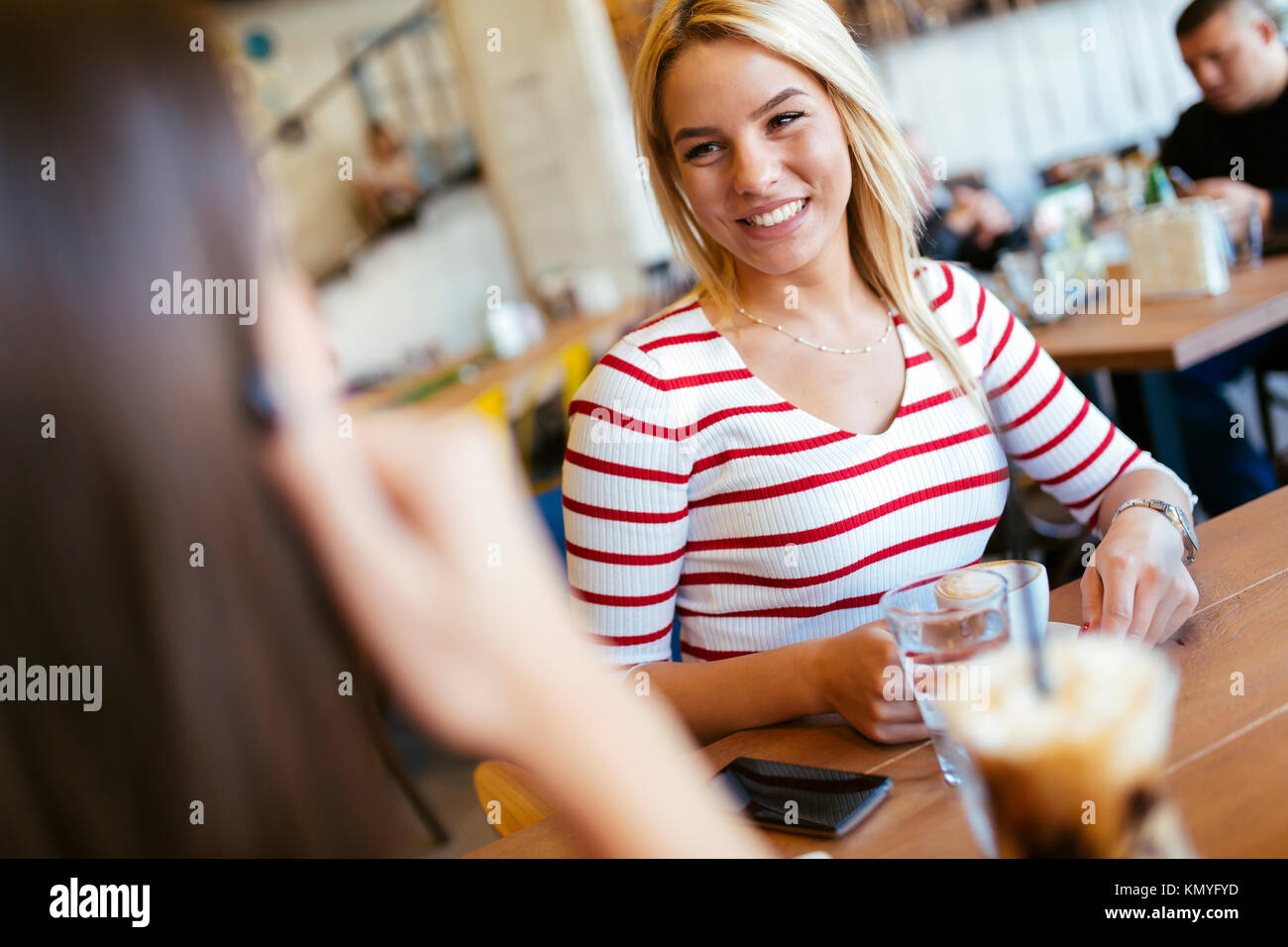 Schöne Frauen trinken Kaffee und Klatsch Stockfoto