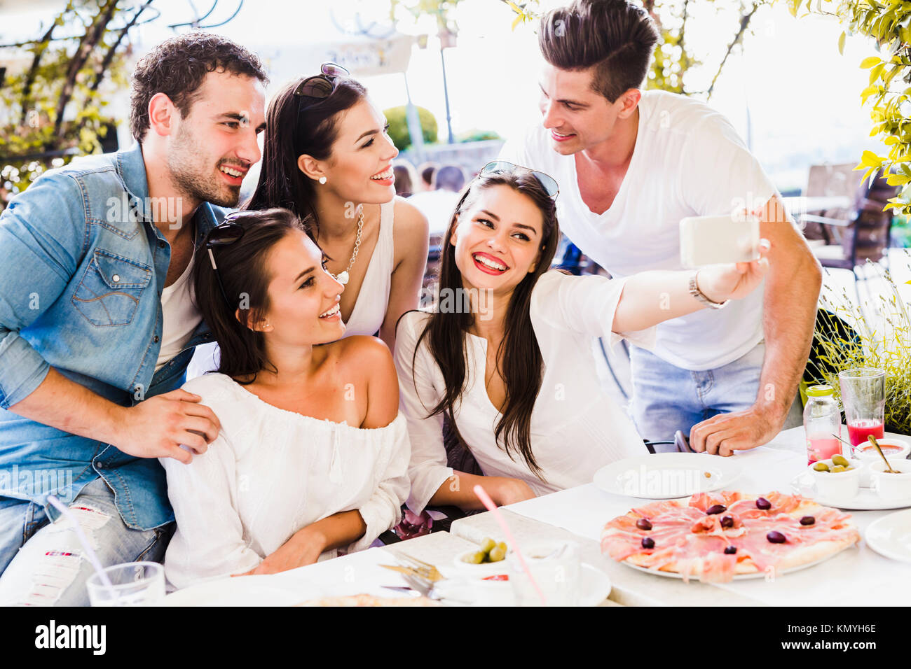 Gruppe junge schöne Menschen sitzen in einem Restaurant und Taki Stockfoto