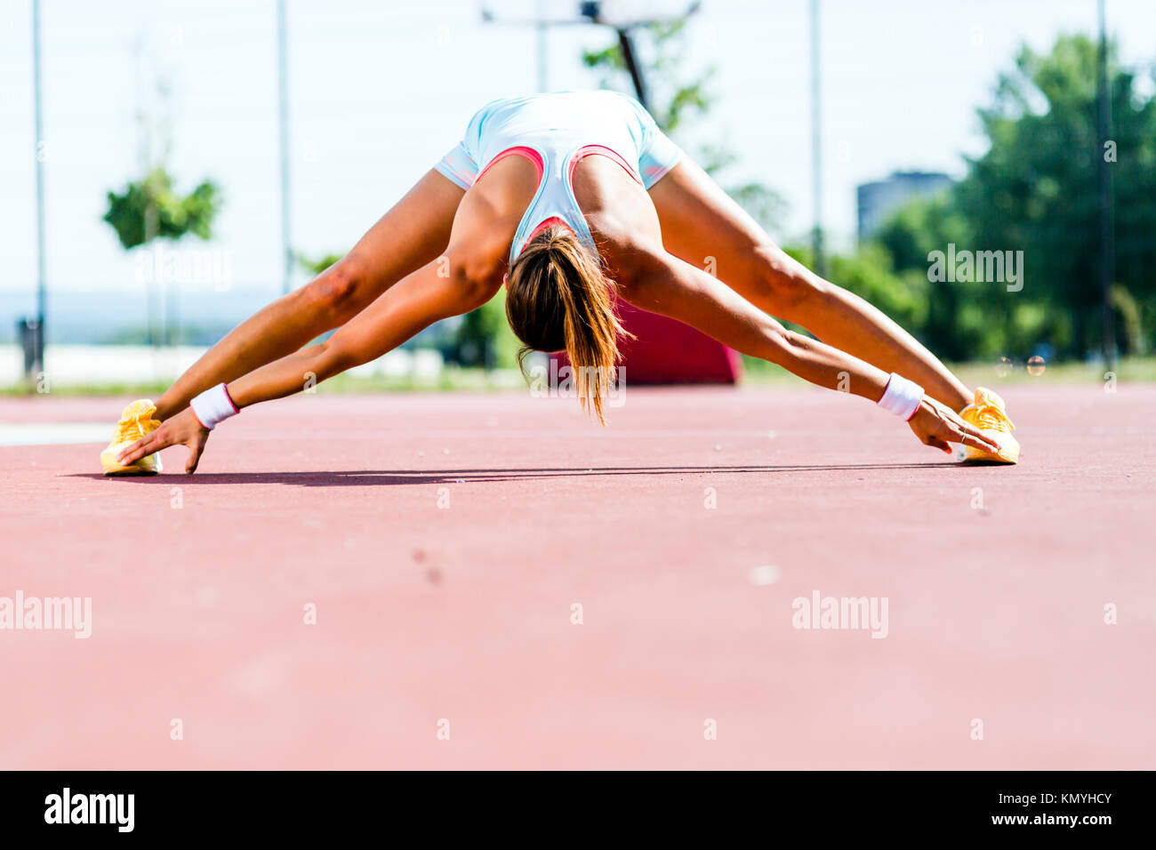Schöne junge athletische Frau Stretching im Sommer Stockfoto