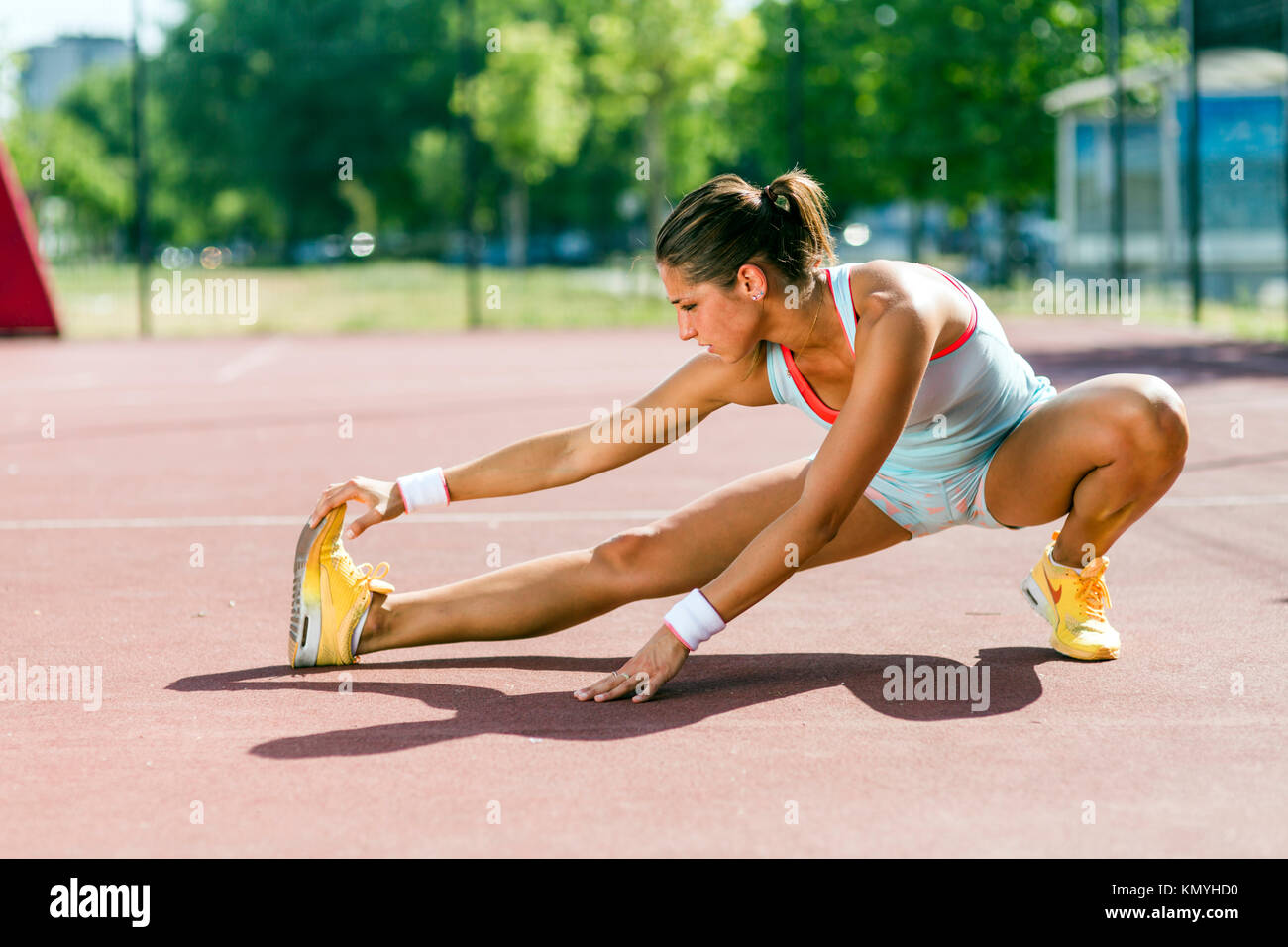 Schöne junge athletische Frau Stretching im Sommer Stockfoto
