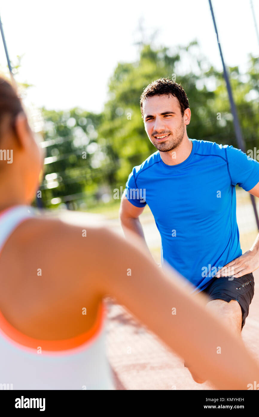 Jungen athletischen Mann und Frau Stretching im Freien auf einen heißen Sommer Stockfoto