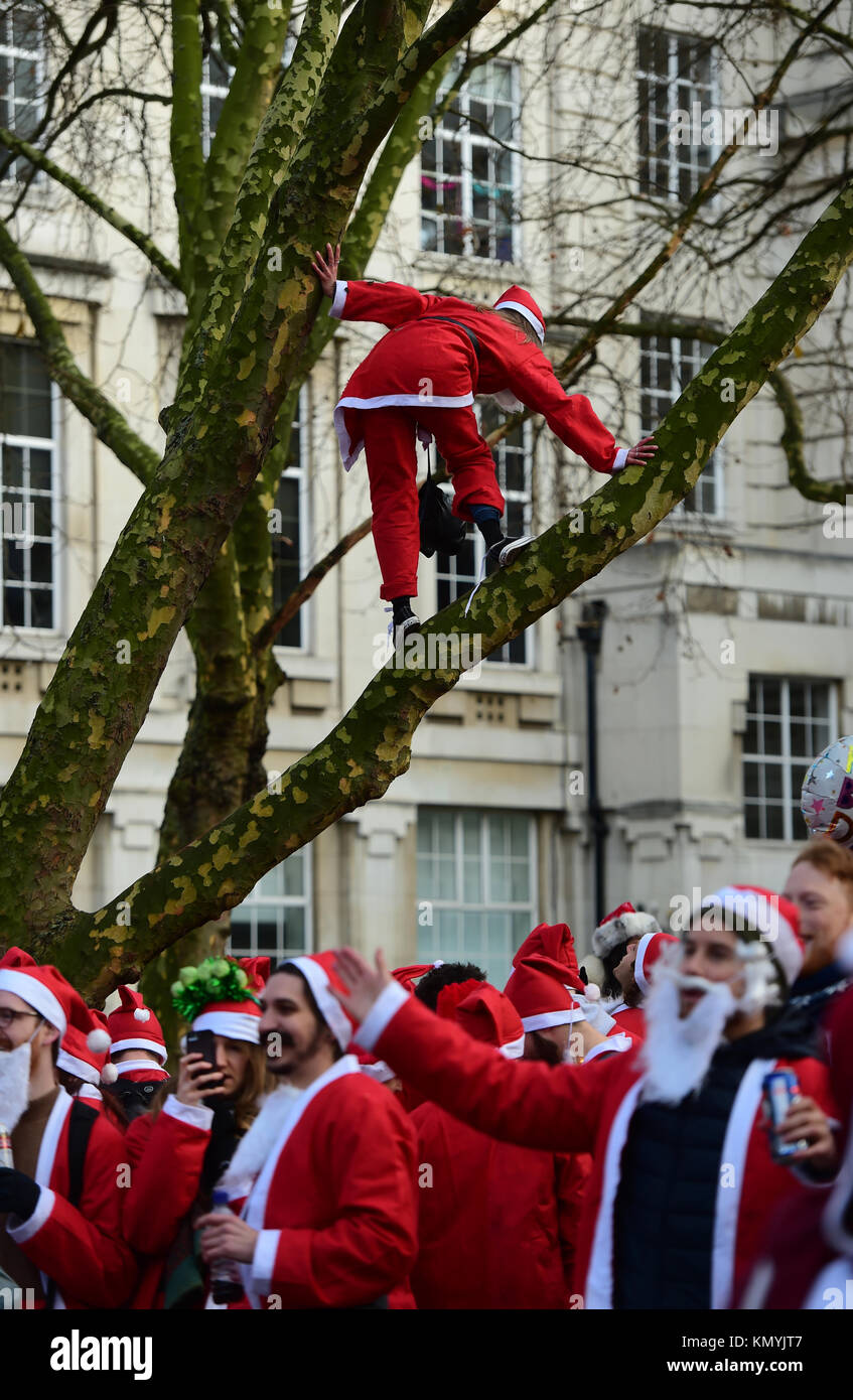 Die Teilnehmer machen sich auf den Weg durch die Straßen von London, wie sie in London 2017 Santacon nehmen. Stockfoto