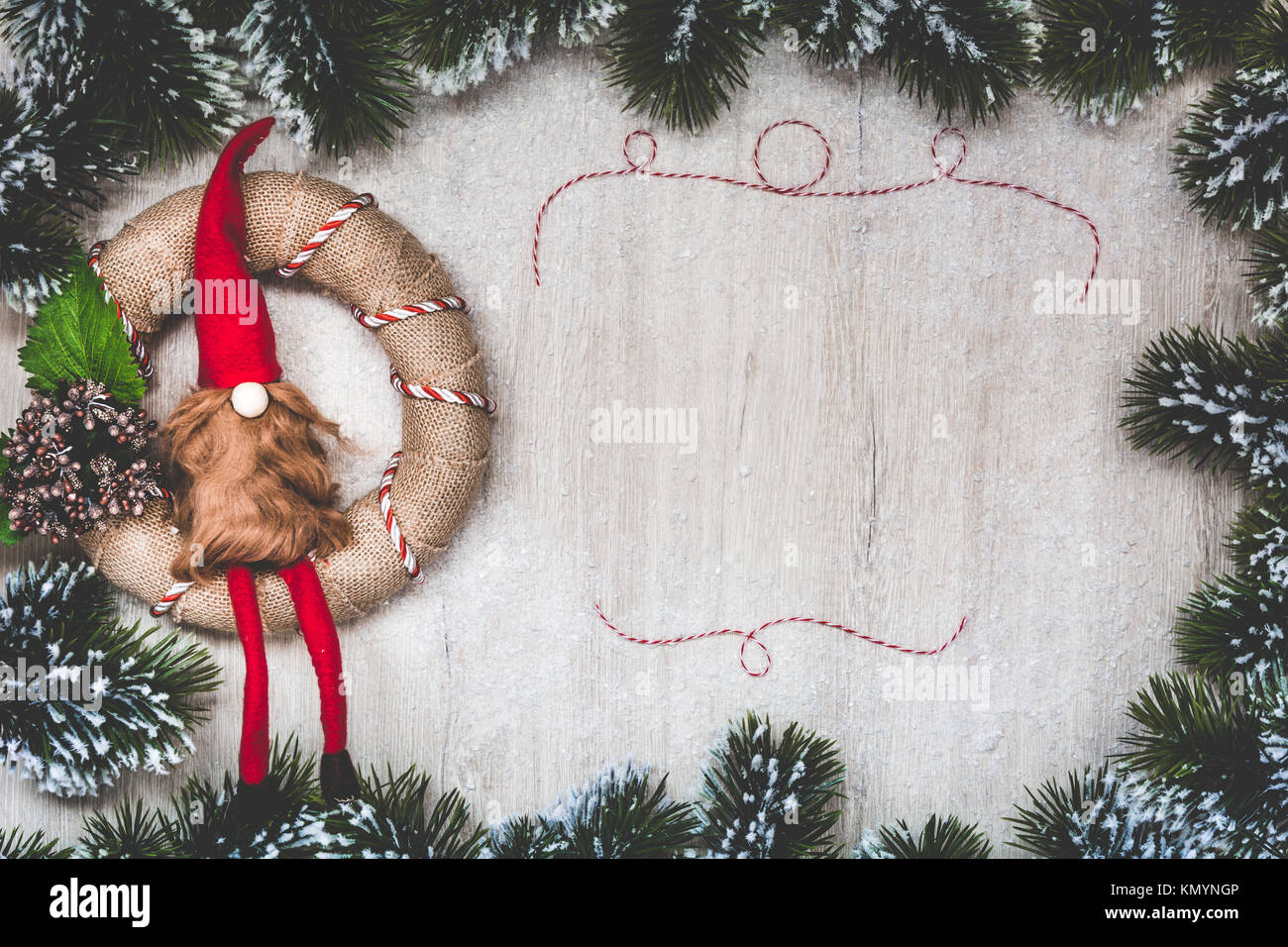 Weihnachten Grußkarte. Weihnachten Hintergrund mit Schnee Tannenbaum und Nordic Weihnachten Kranz handgefertigt. Sicht von oben mit Platz für ihre Grüße. Stockfoto