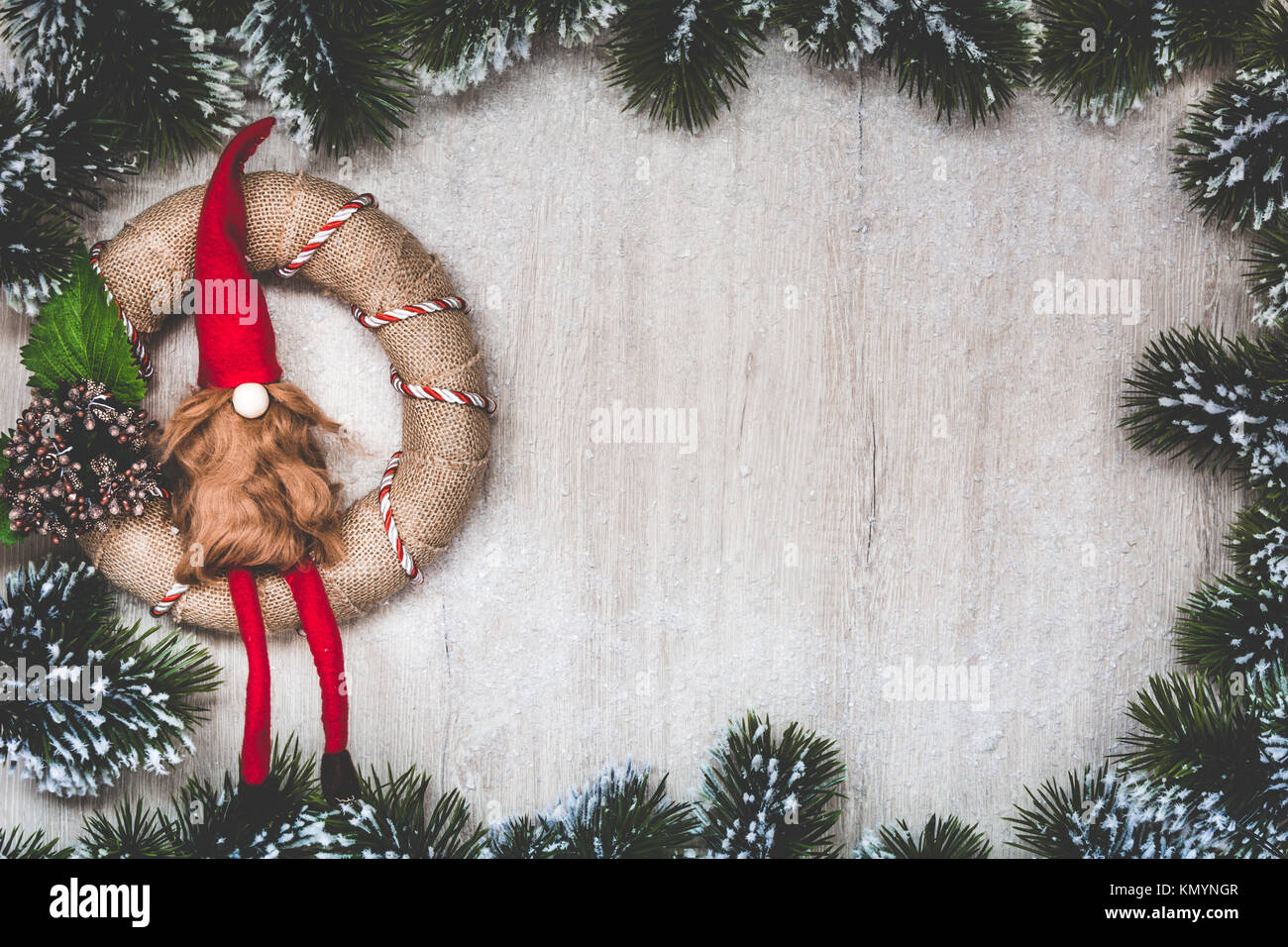 Weihnachten Grußkarte. Weihnachten Hintergrund mit Schnee Tannenbaum und Nordic Weihnachten Kranz handgefertigt. Sicht von oben mit Platz für ihre Grüße. Stockfoto