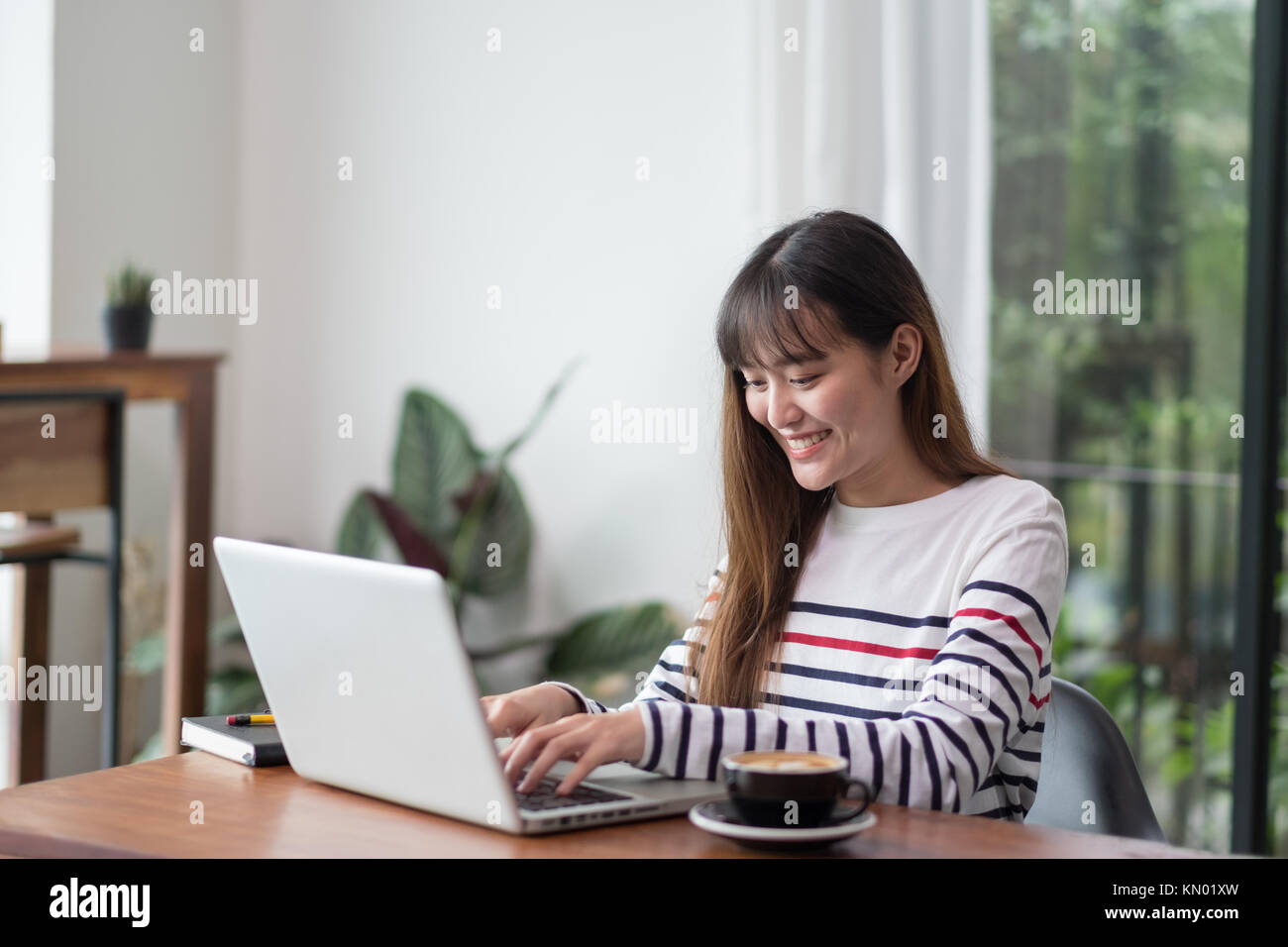 Asiatische Frau mit Laptop in der Nähe der Fenster im Cafe Restaurant, Digital Lifestyle, mit Technologie Konzept, co Arbeitsbereich Stockfoto