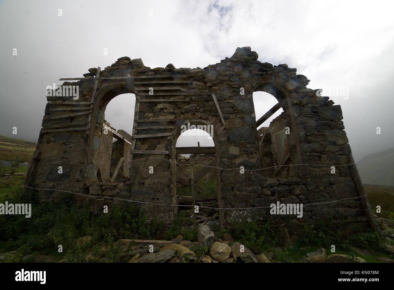 Die alte steinerne Ruinen eines Gebäudes links in Snowdonia National Park aufgegeben, verlassenen Kirche oder verlassene Kapelle verfiel, auf Weitwinkel. Stockfoto