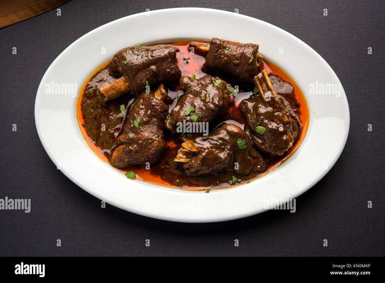 Lammkeule oder Hammel- oder gosht paya oder khoor Curry mit indischen Brot oder Roti oder Naan serviert. Stockfoto