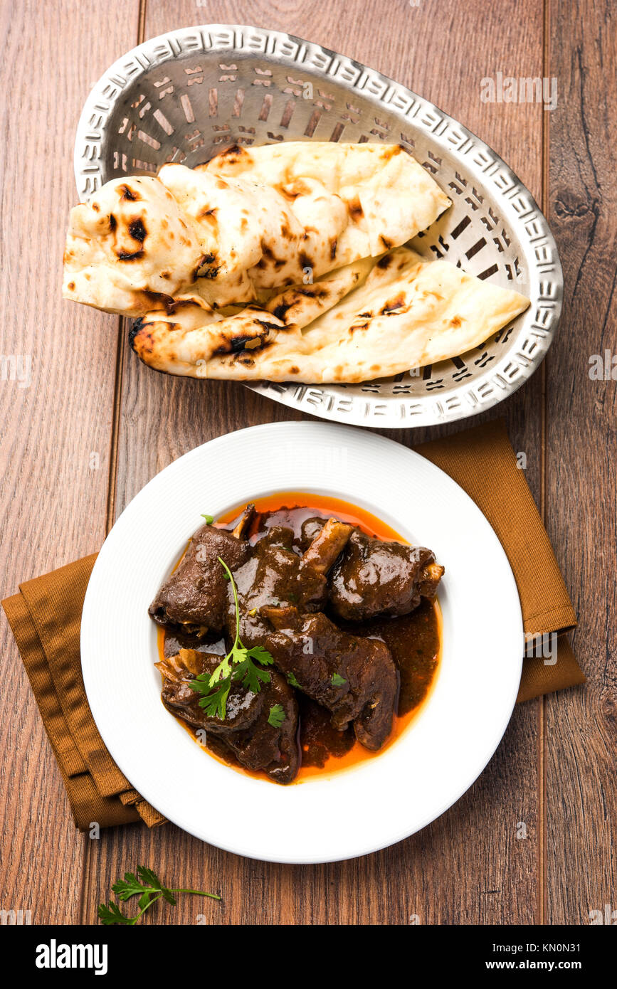 Lammkeule oder Hammel- oder gosht paya oder khoor Curry mit indischen Brot oder Roti oder Naan serviert. Stockfoto