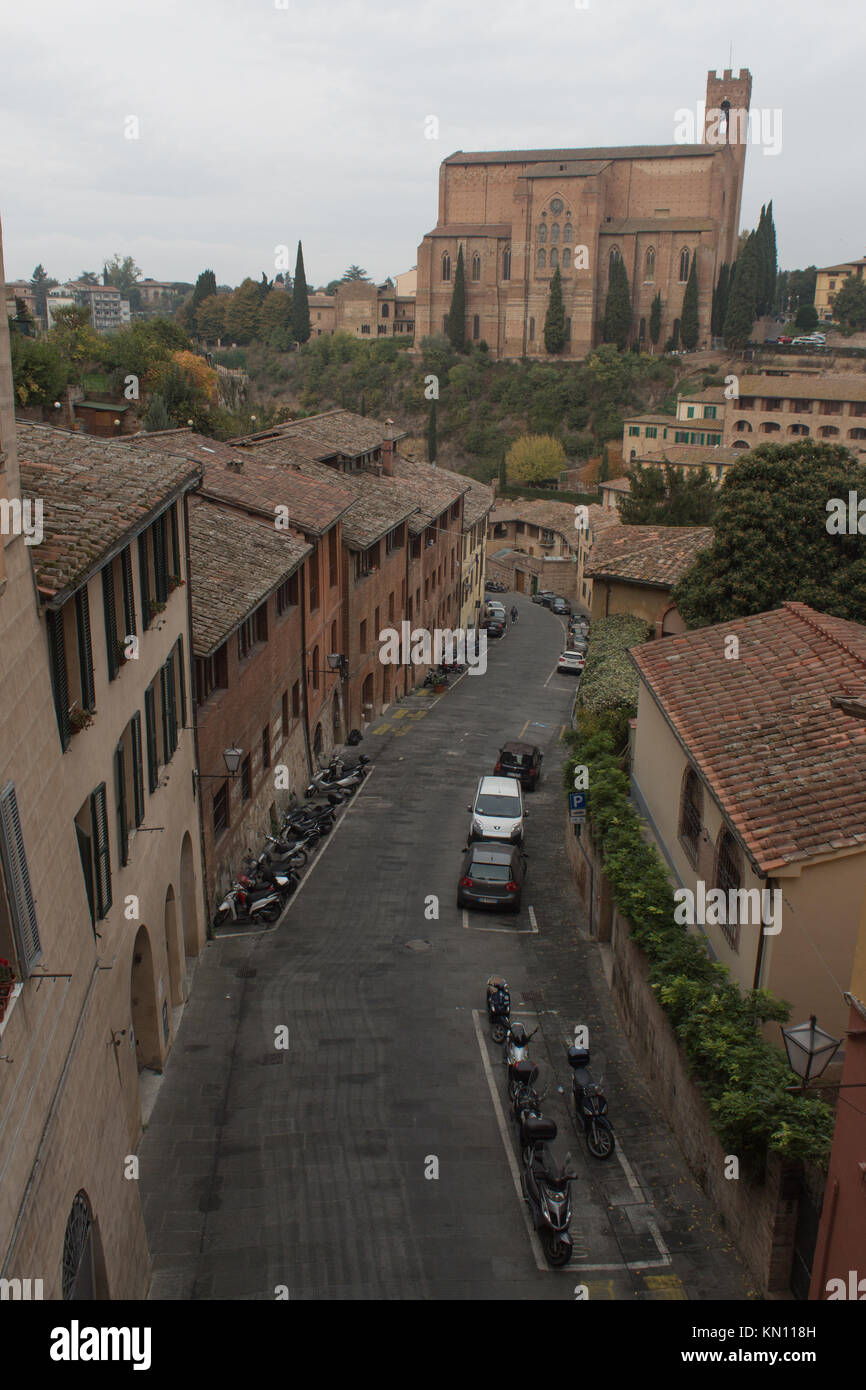 Blick auf Basicila Cateriniana San Domenico mit Straße und Häuser unten. Siena, Italien. Stockfoto