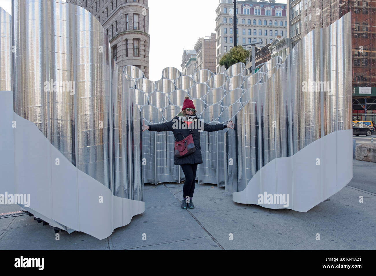 Ein tourist für Fotos vor der Skulptur Flatiron Reflexionen der Zukunft Ausdruck im Flatiron District von New York City. Stockfoto