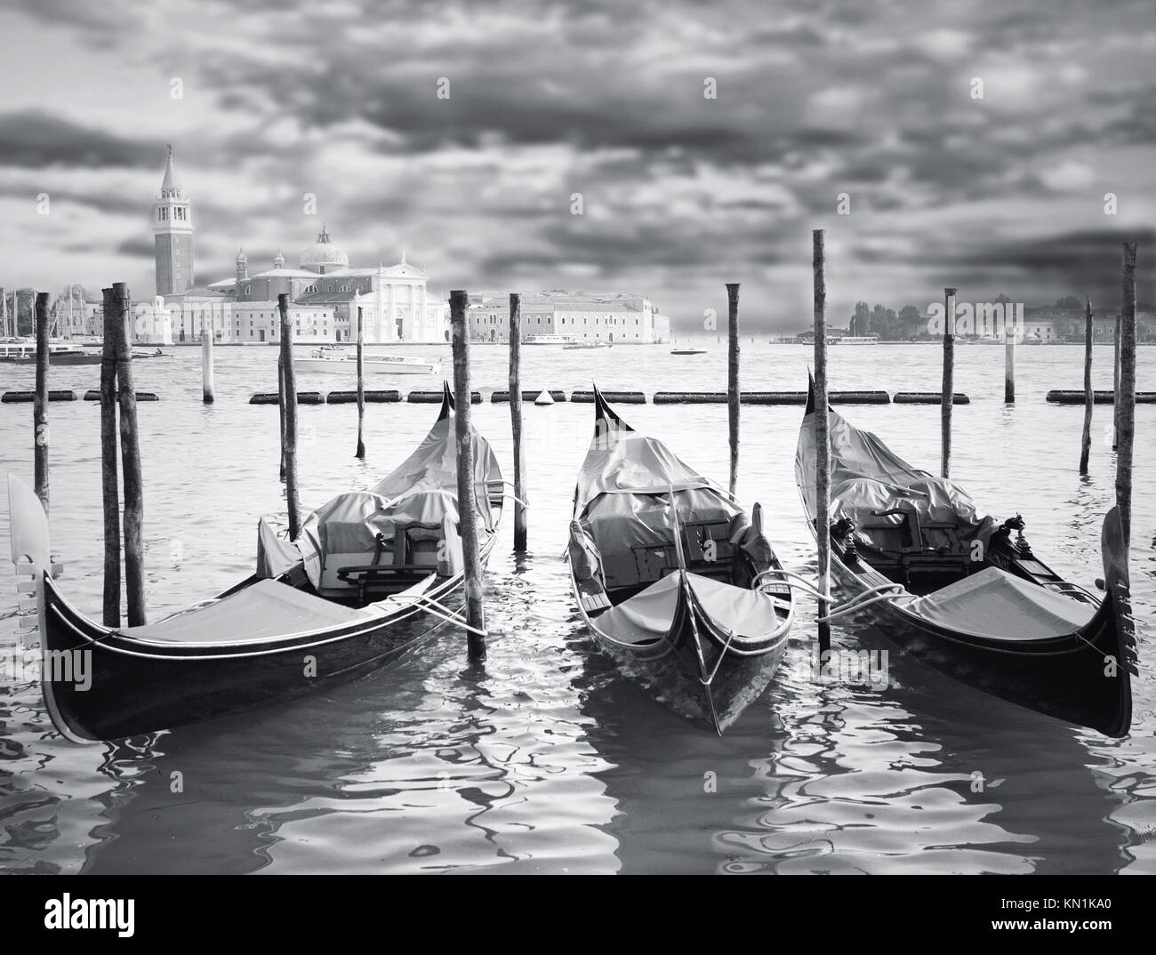 Wunderbare Aussicht auf drei Gondel parken in Canal Grande mit der Insel mit - Basilika der Jungfrau Maria der guten Gesundheit - und dramatischen Himmel auf der backgroun Stockfoto