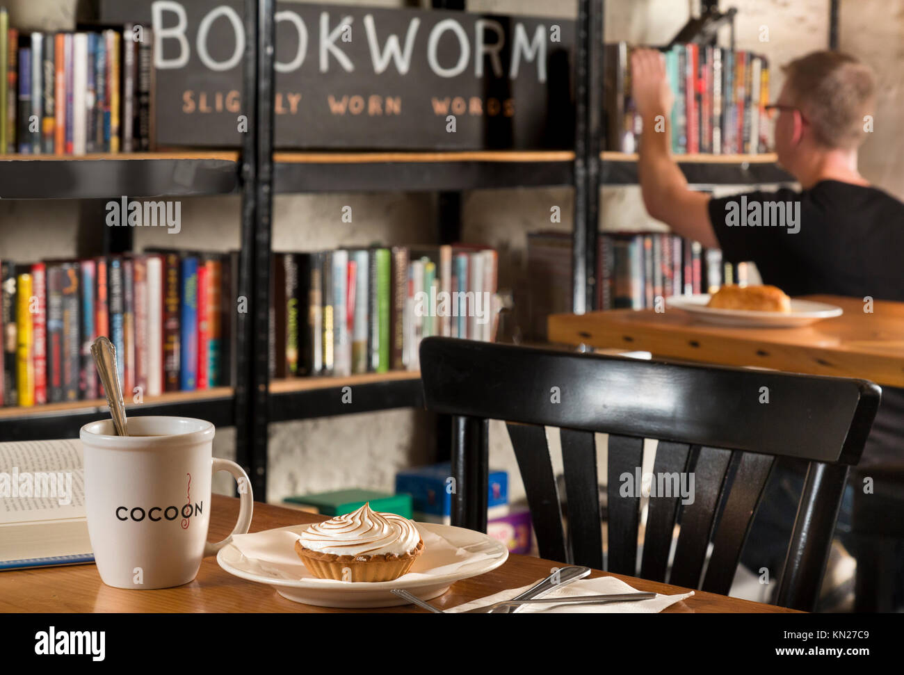 Bücher in Coffeeshop mit Tasse und Essen, Cocoon Coffee House, Hawley, Pennsylvania, USA, Stockfoto