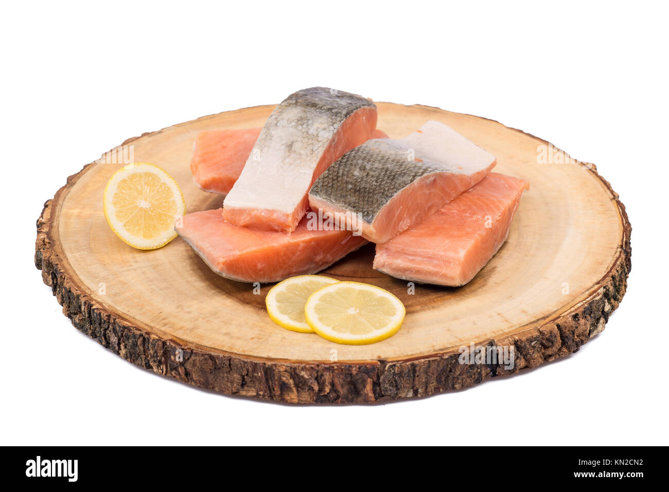 Gefrorenen lachs Fischfilets mit Zitronenscheiben auf Holz board isoliert. Stockfoto