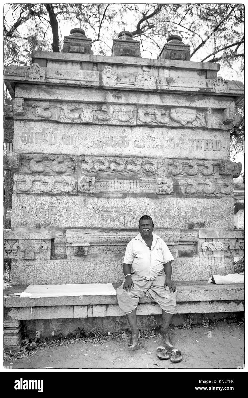 Schwarz-weiß-Porträt eines indischen Mann sitzt vor einem zerstörten Statue Posieren fürs Foto Stockfoto