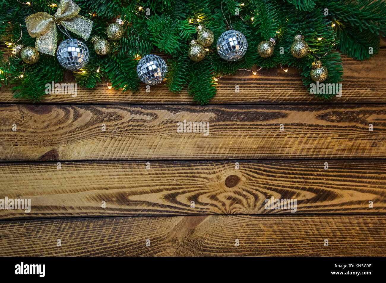 Weihnachten Hintergrund mit Tannenzweigen und Glanz Kugeln über dunklem Holz Stockfoto