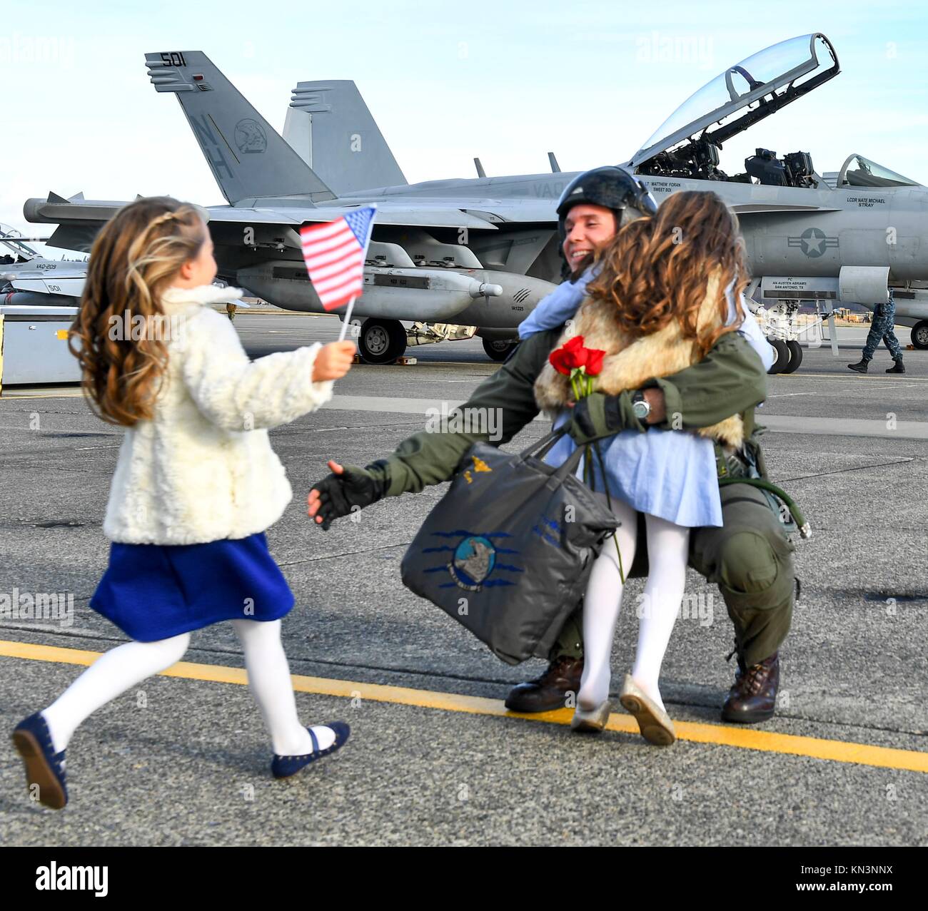 Ein U.S. Navy sailor Umarmungen hils Kinder bei der Ankunft im Naval Air Station Whidbey Island nach der Rückkehr von der Bereitstellung 4. Dezember in Oak Harbor, Washington 2017. (Foto durch Joseph E. Montemarano über Planetpix) Stockfoto