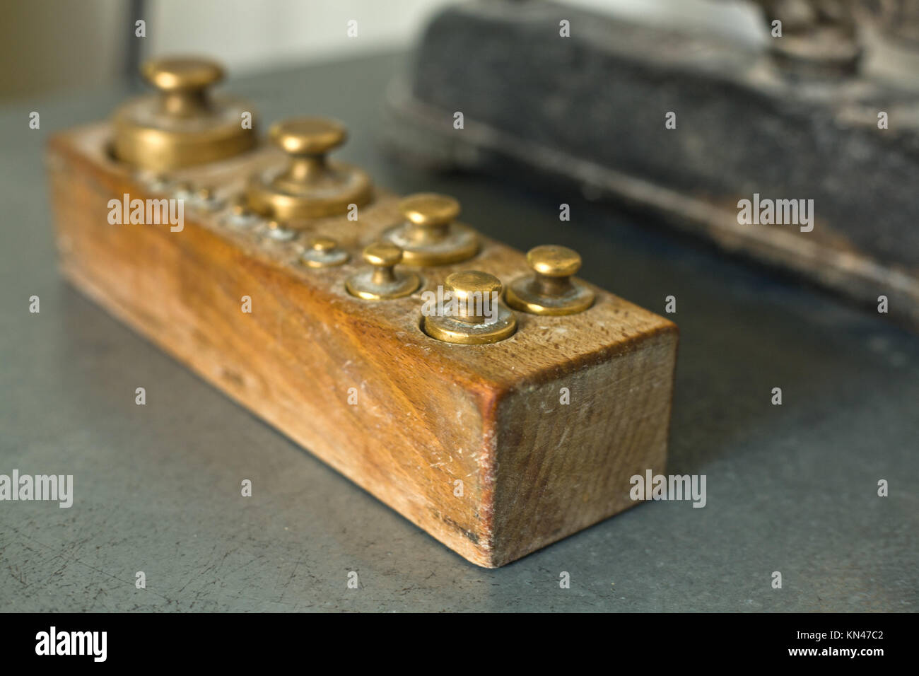 Alte vintage Messing Gewichte für Waagen Teig in einer Bäckerei in einer Holzkiste. Stockfoto