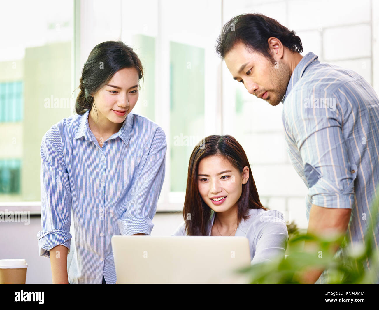Team von jungen asiatischen Geschäftsleuten in Freizeitkleidung zusammen arbeiten im Büro mit Laptop Computer. Stockfoto