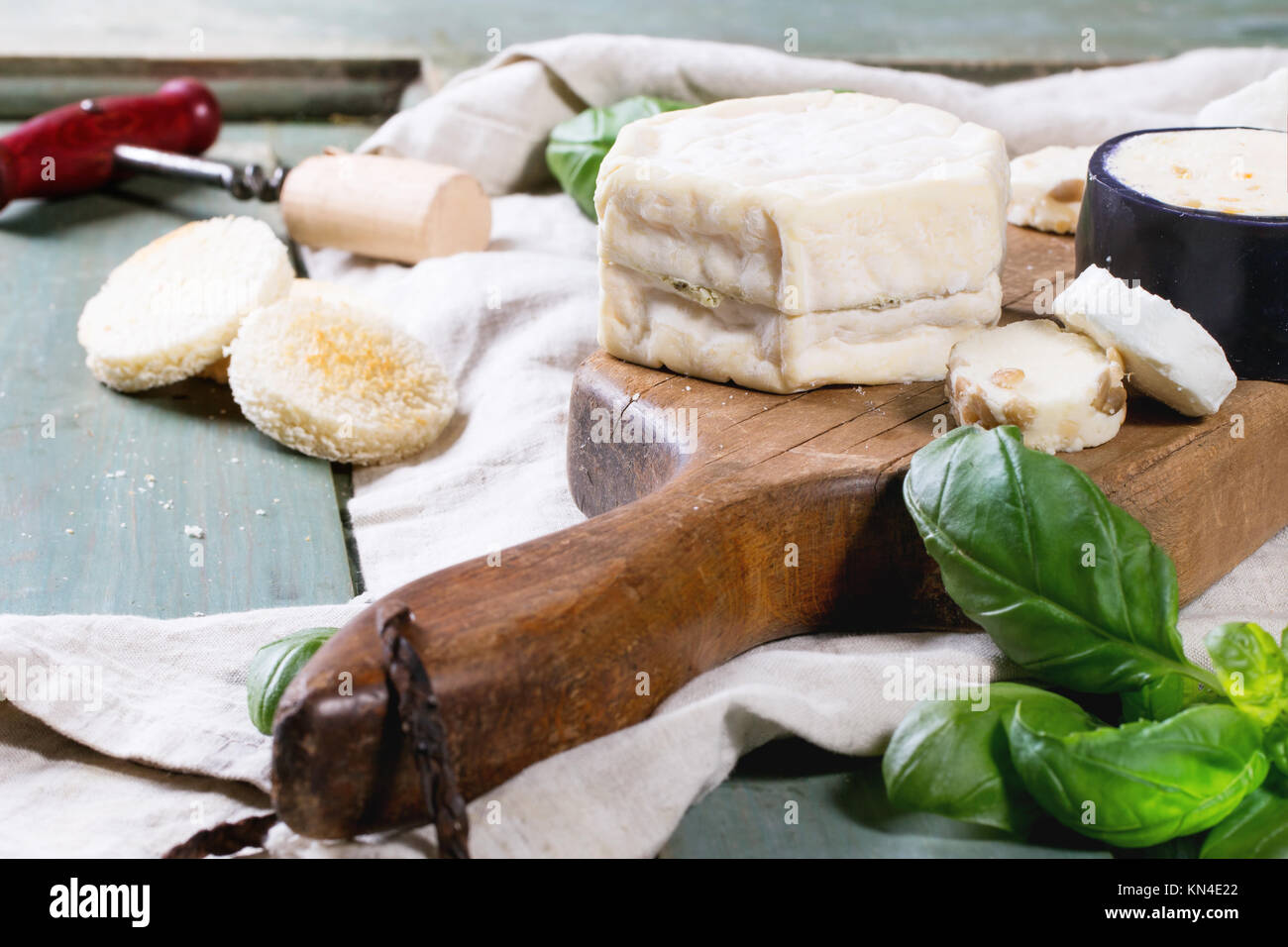 Variation von Käse mit frischem Basilikum und Breadover Türkis Holztisch auf Holzbrett serviert. Serien ansehen Stockfoto