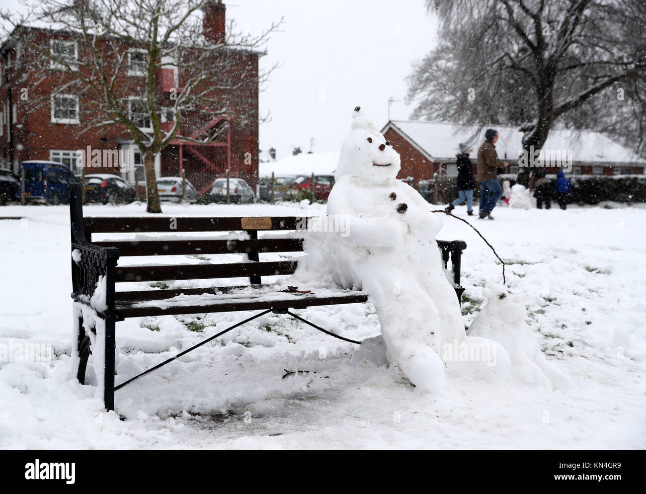 Ein Schneemann auf einer Bank, Worcester, wie starker Schneefall über Teile von Großbritannien weitverbreitete Störungen verursacht, schließen Straßen und Erdung Flüge am Flughafen. Stockfoto