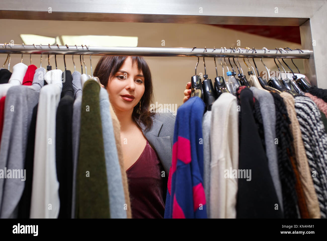 Frau entscheidet, Kleidung im Store. Stockfoto