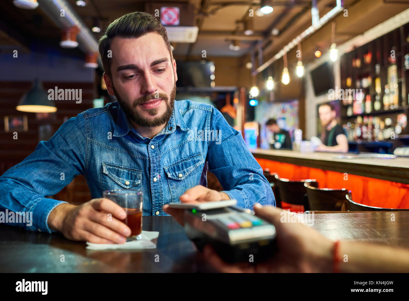 Betrunkener Mann Zahlen über NFC in Pub Stockfoto