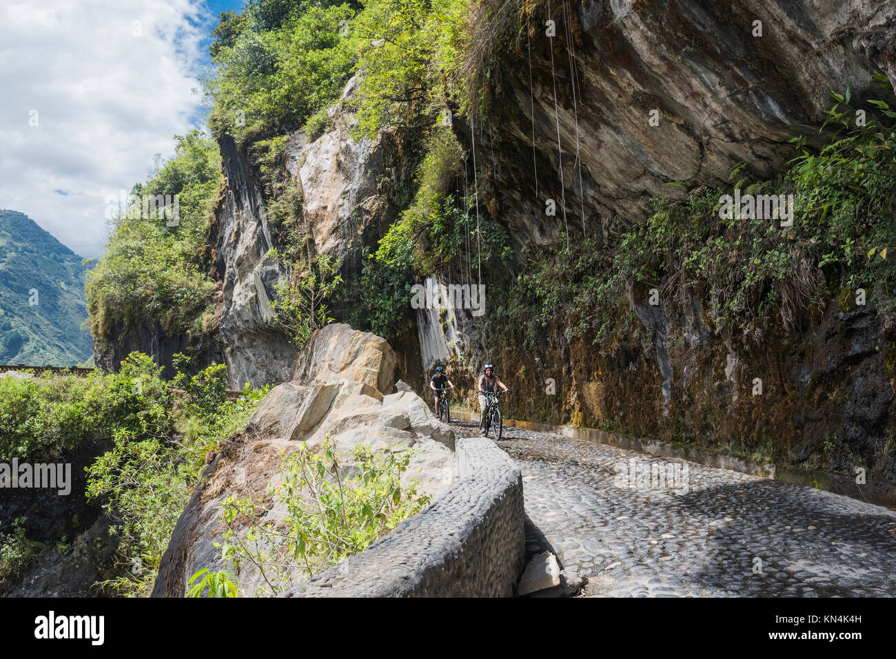 Cascades route, Banos - Puyo, Ecuador - Dezember 8, 2017: Touristen fahren Fahrräder entlang der Wasserfälle Straße über den Abgrund der Schlucht Stockfoto