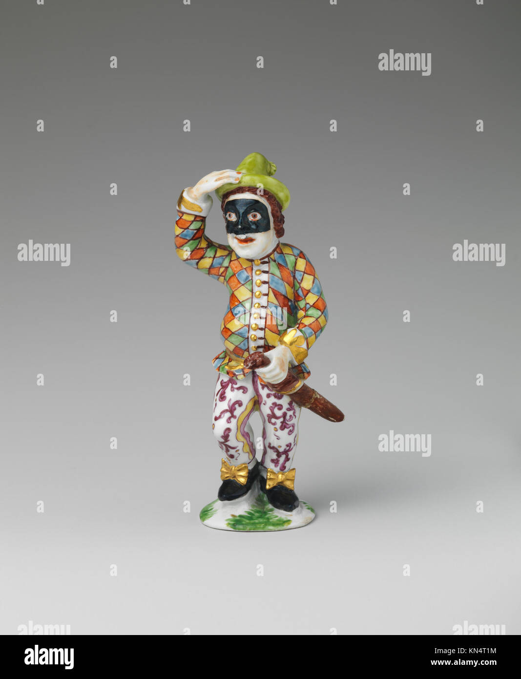 Harlequin-Figur aus der italienischen Commedia dell'Arte, die traditionelles Kostümdesign und seine Rolle bei der Theateraufführung zeigt. Stockfoto