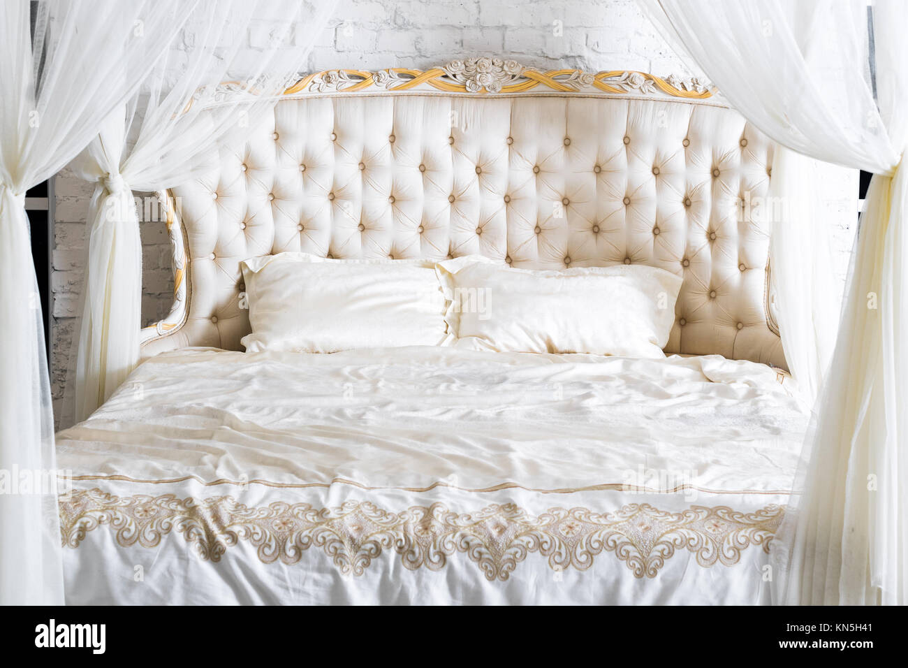 Schlafzimmer in sanften hellen Farben. Großes bequemes Himmelbett  Doppelbett in eleganten klassischen Schlafzimmer. Luxus weiss mit gold  interior design Stockfotografie - Alamy