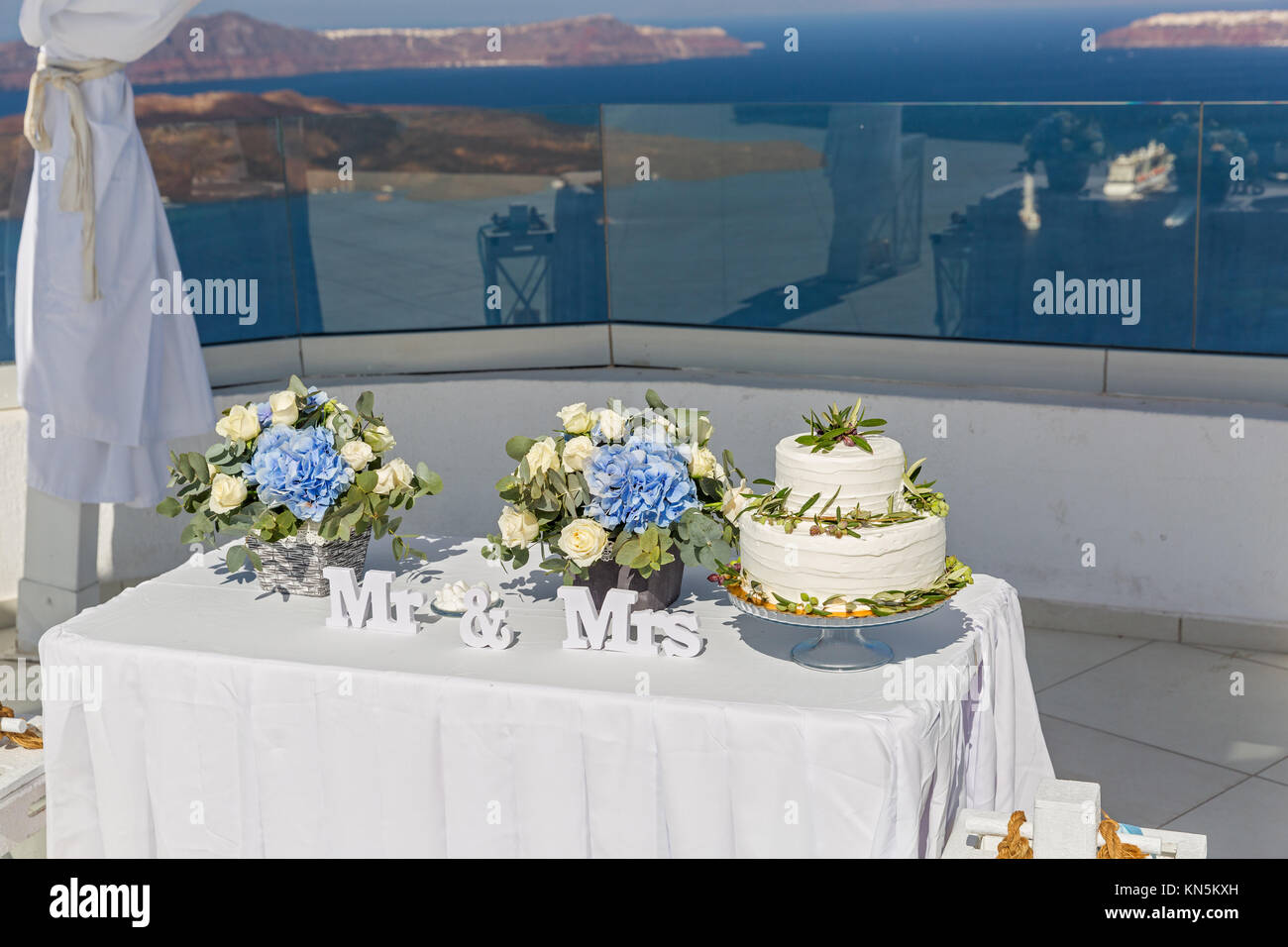 Dekorationen mit Blumen und Torte für die Hochzeit auf dem Hintergrund des Meeres Stockfoto