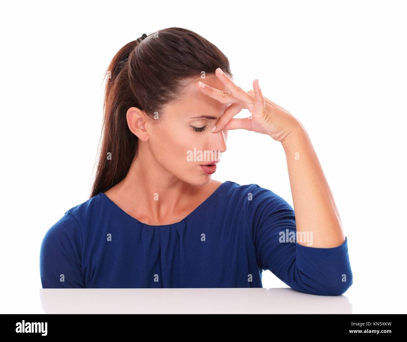 Hübsche Dame mit geschlossenen Augen leiden Kopfschmerzen in den weißen Hintergrund. Stockfoto