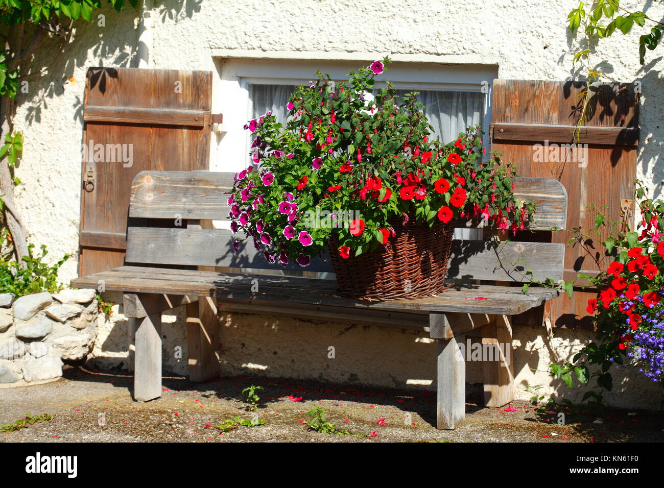 Blumentopf auf einer Holzbank mit Blumen, typische Holzhaus