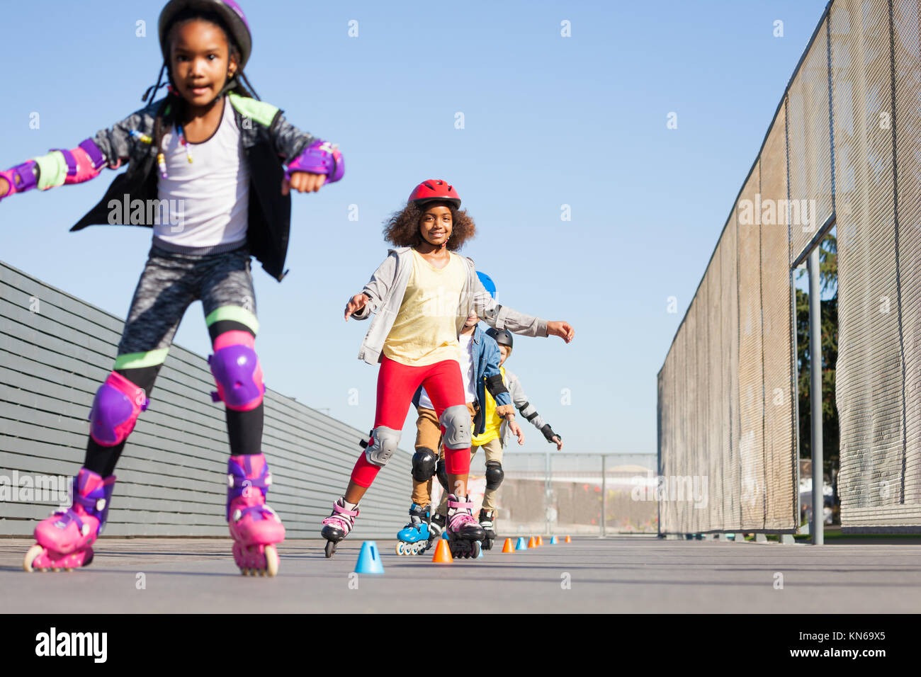 Portrait der afrikanischen Mädchen, glücklich, Inline-Skater, vorwärts Lernen slalom an Skate Park an einem sonnigen Tag Stockfoto