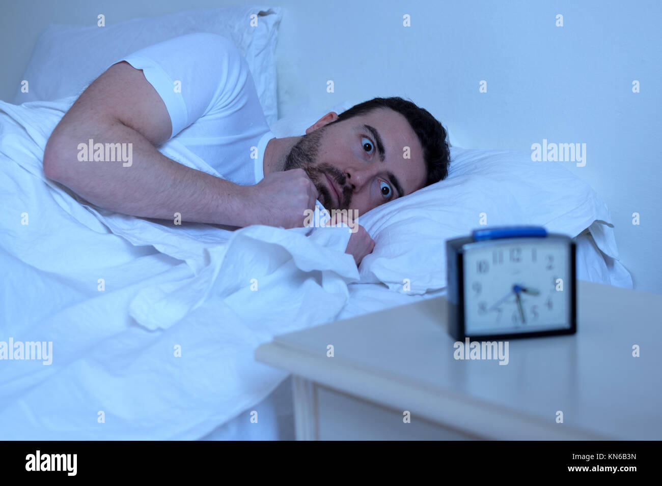 Betonte Mann versucht, in seinem Bett in der Nacht schlafen Stockfoto