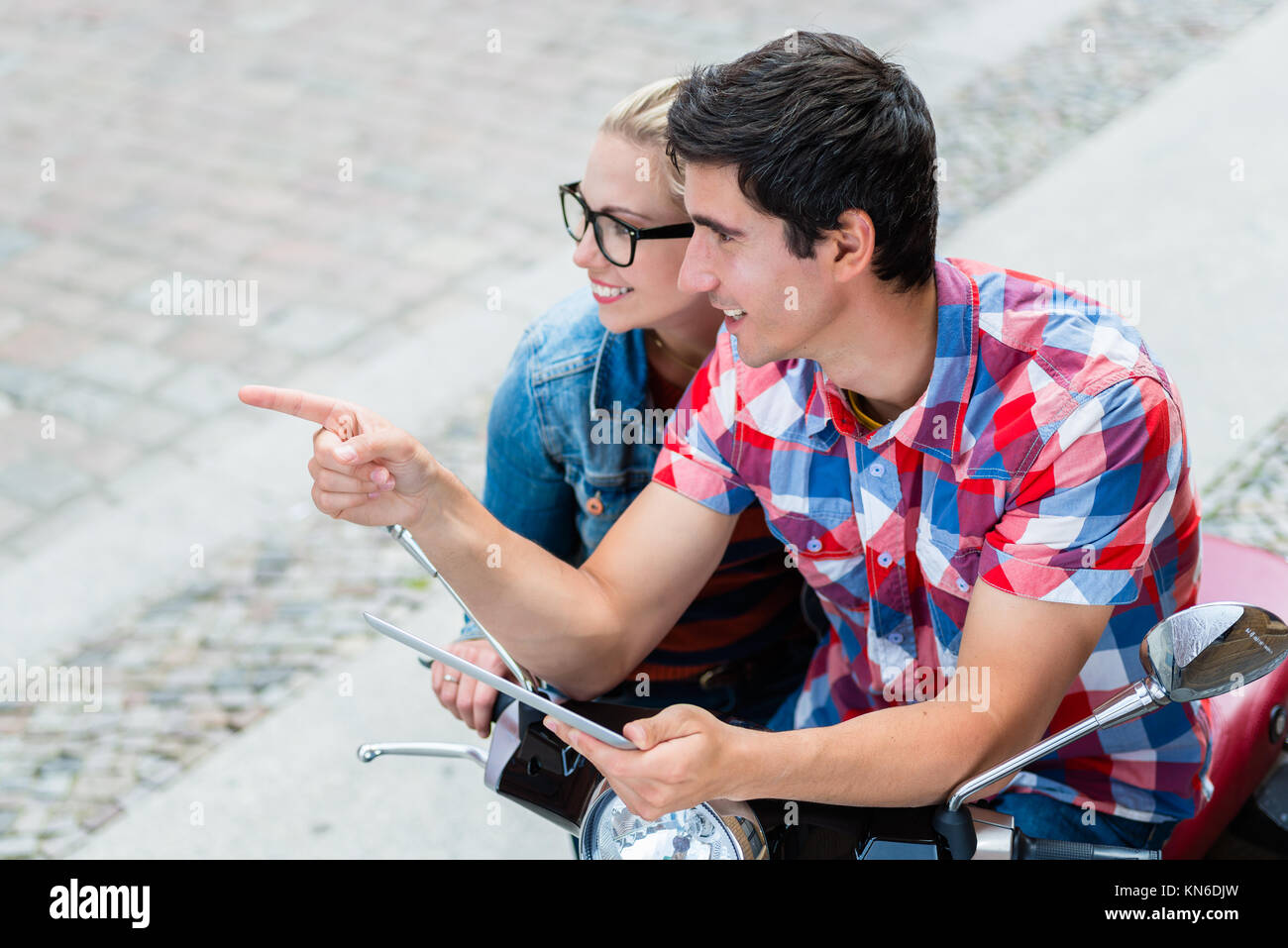 Paar auf Städtereise ihre Vespa tour Planung mit Tablet-PC Stockfoto